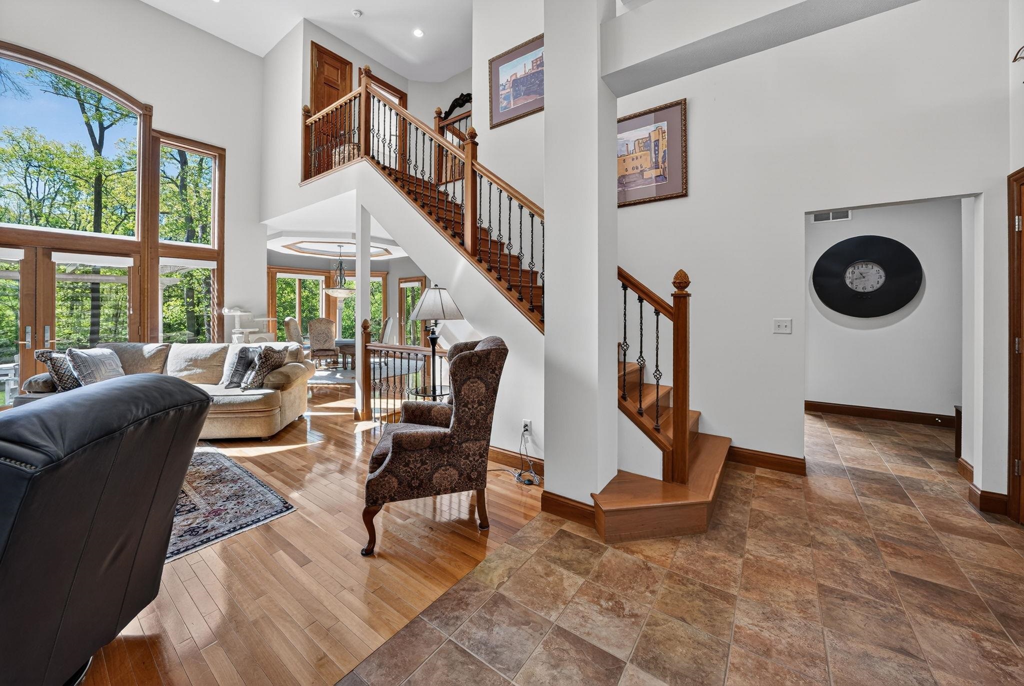Two-story foyer featuring a wood staircase with iron balusters, hardwood flooring, and neutral wall tones