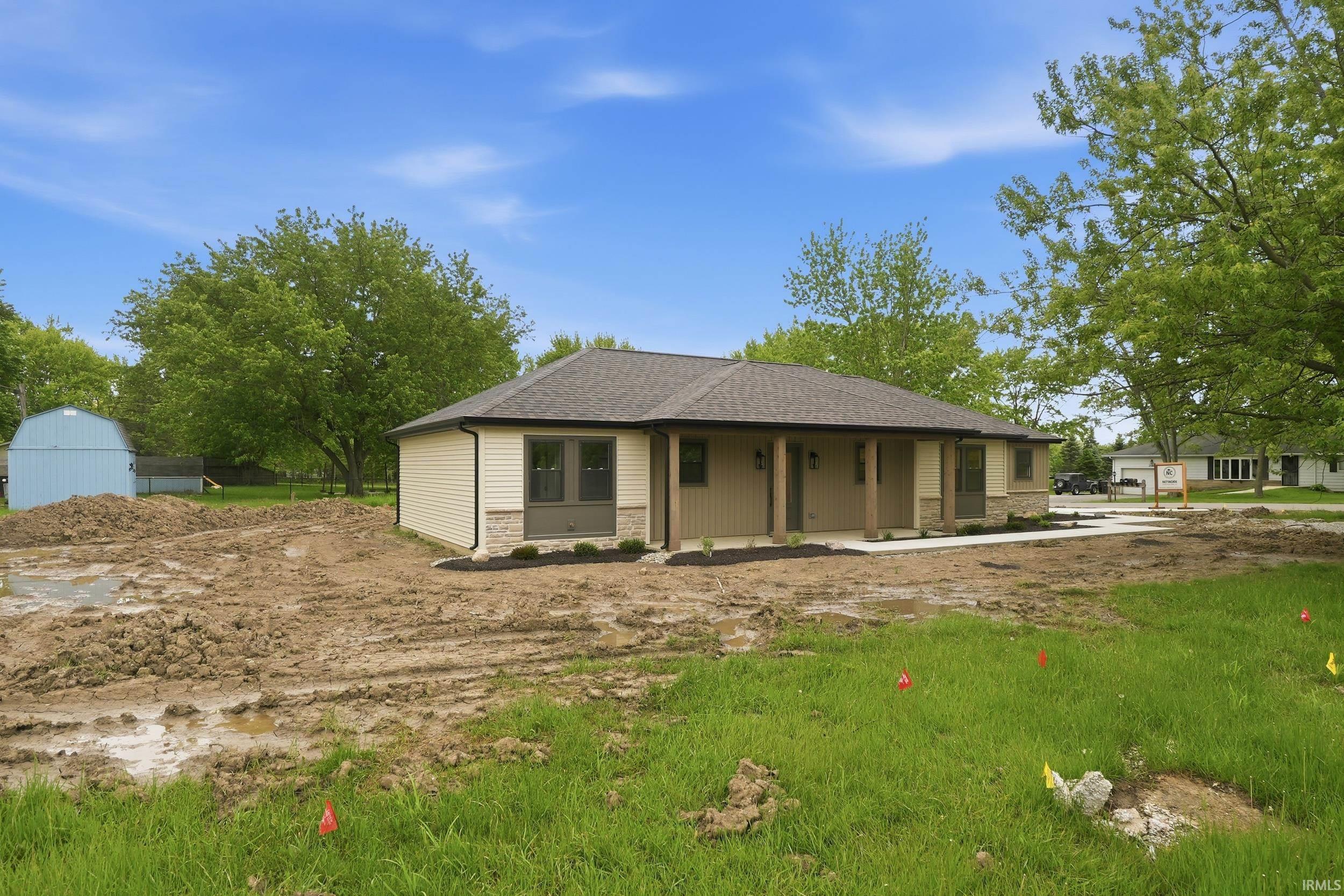 Ranch-style exterior featuring light-colored siding, dark trim, and stone accents