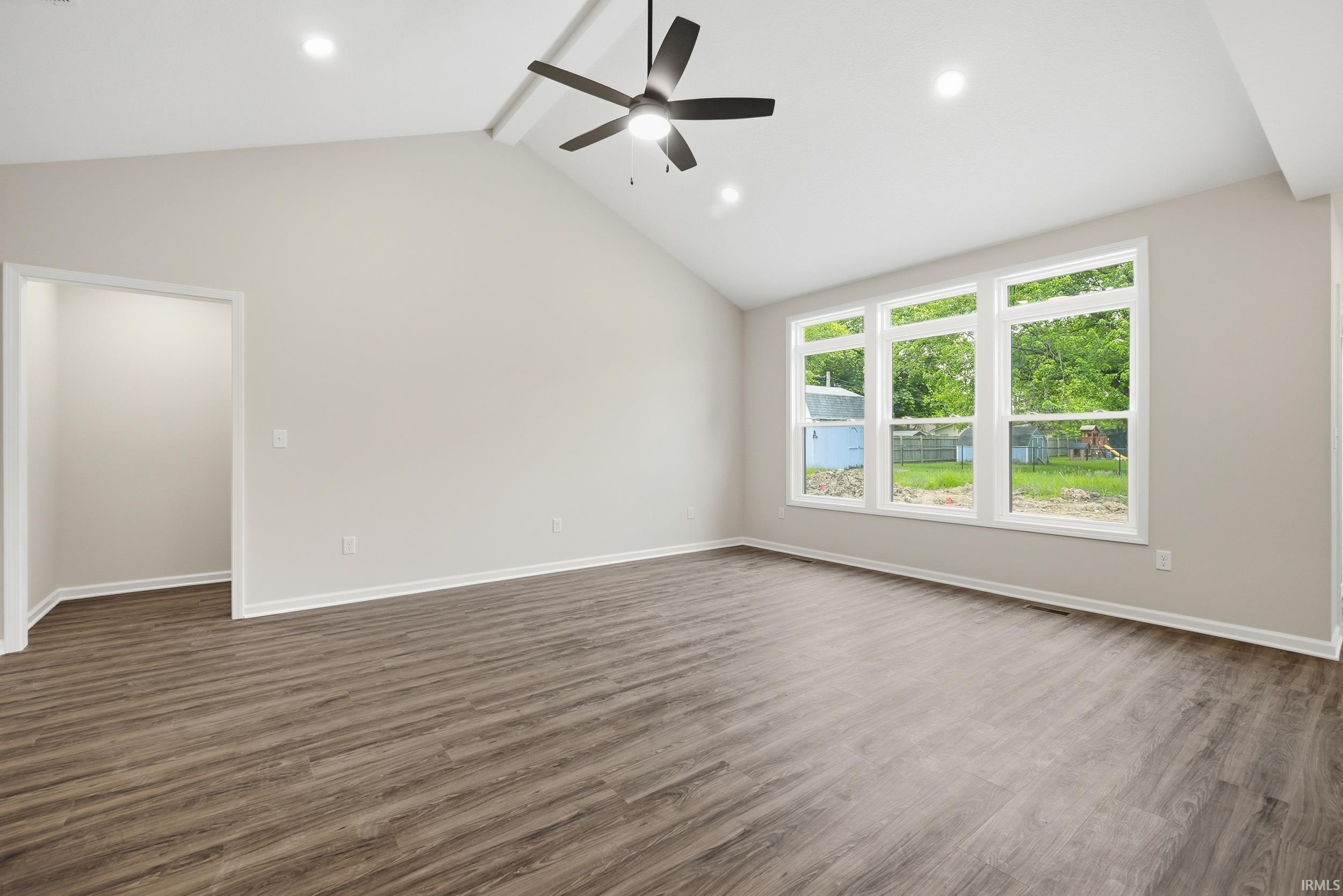 Spacious room featuring vaulted ceilings, a contemporary ceiling fan, and recessed lighting
