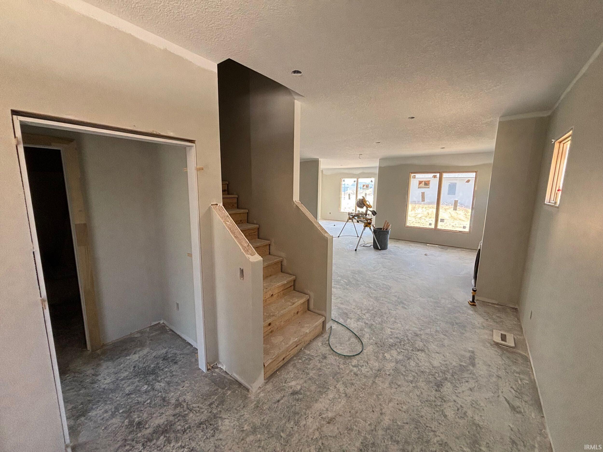Two-story entry foyer with an open staircase and a spacious open-concept living area