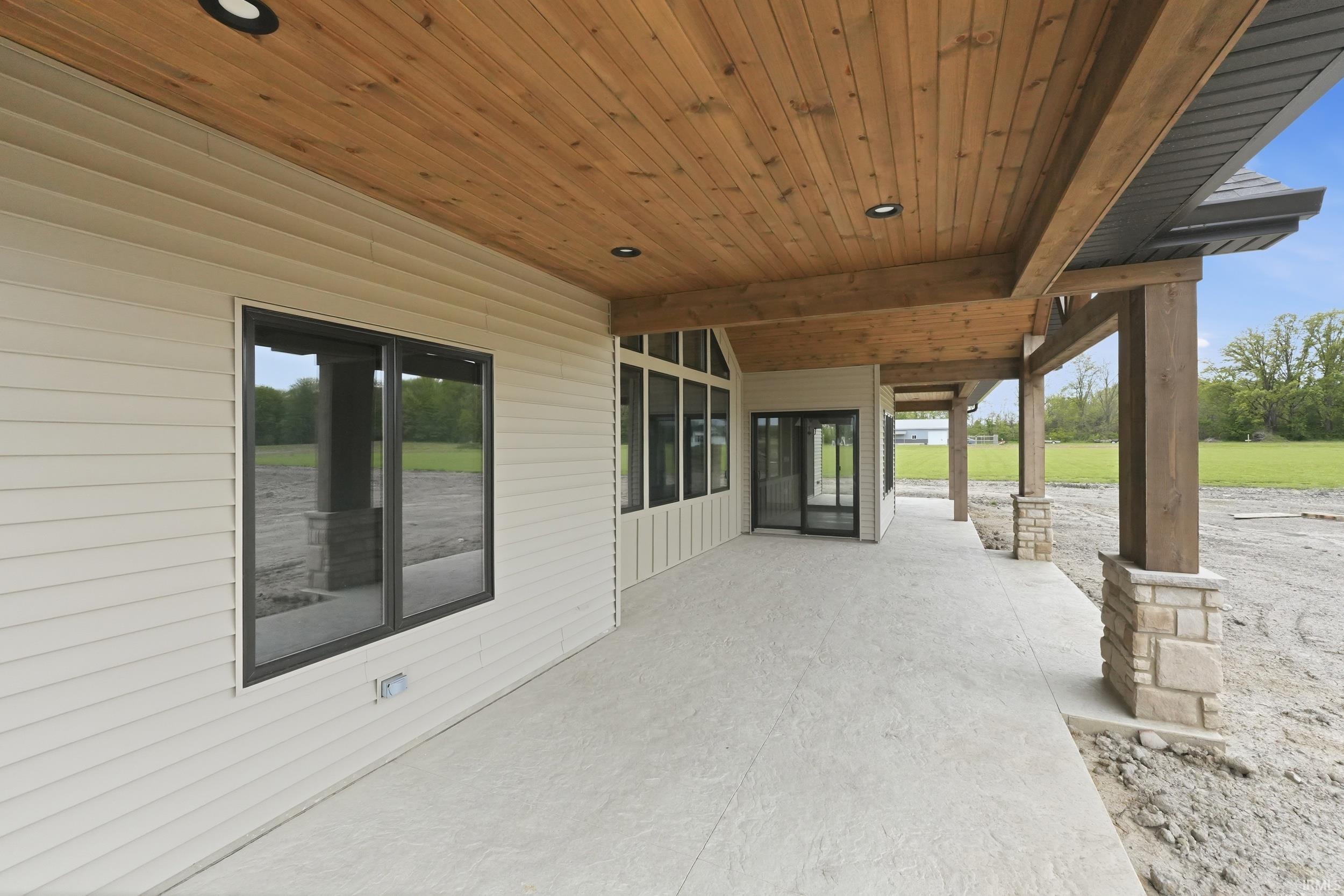 Expansive covered patio featuring a wood-finish ceiling with recessed lighting
