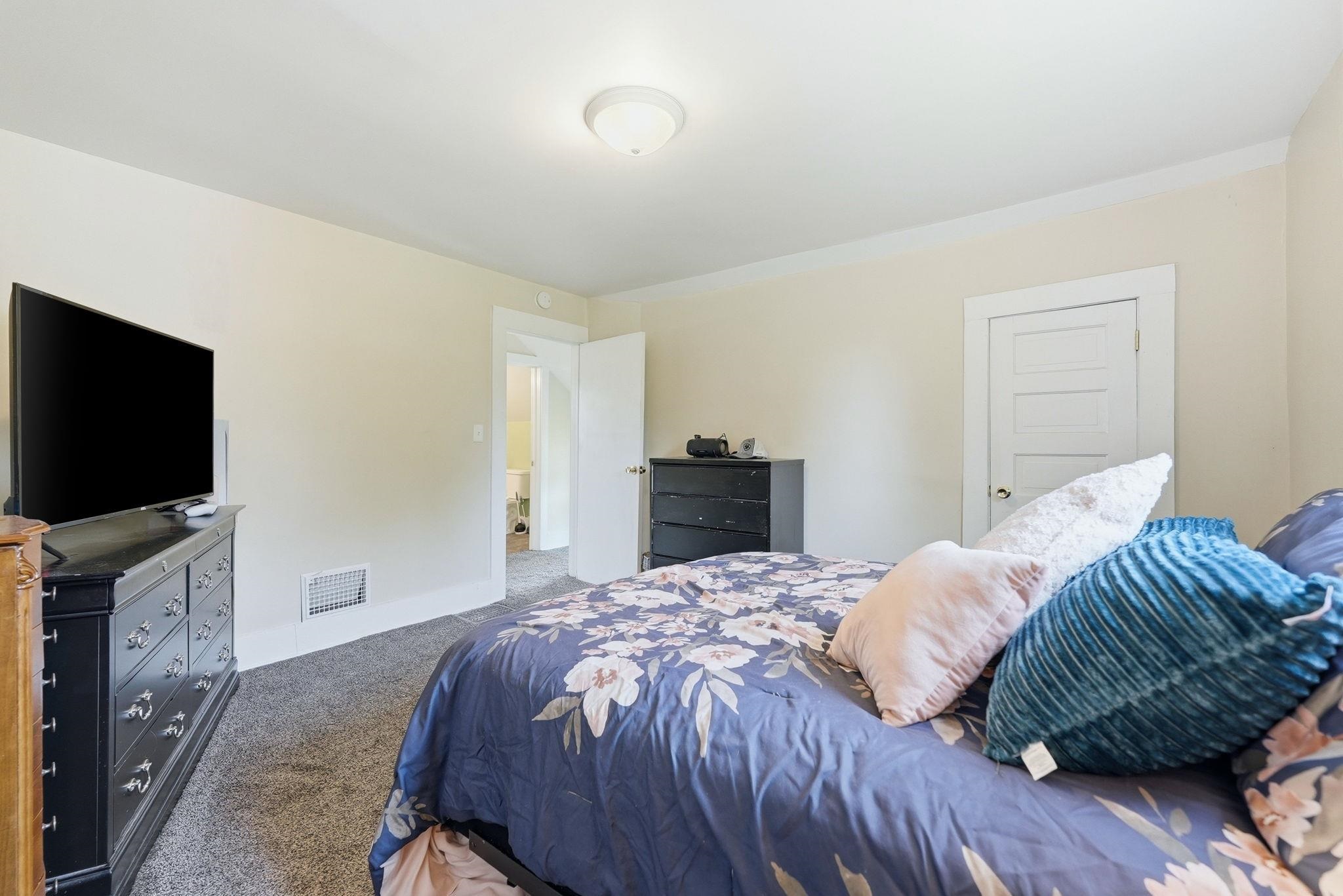 Carpeted room with a ceiling-mounted light fixture