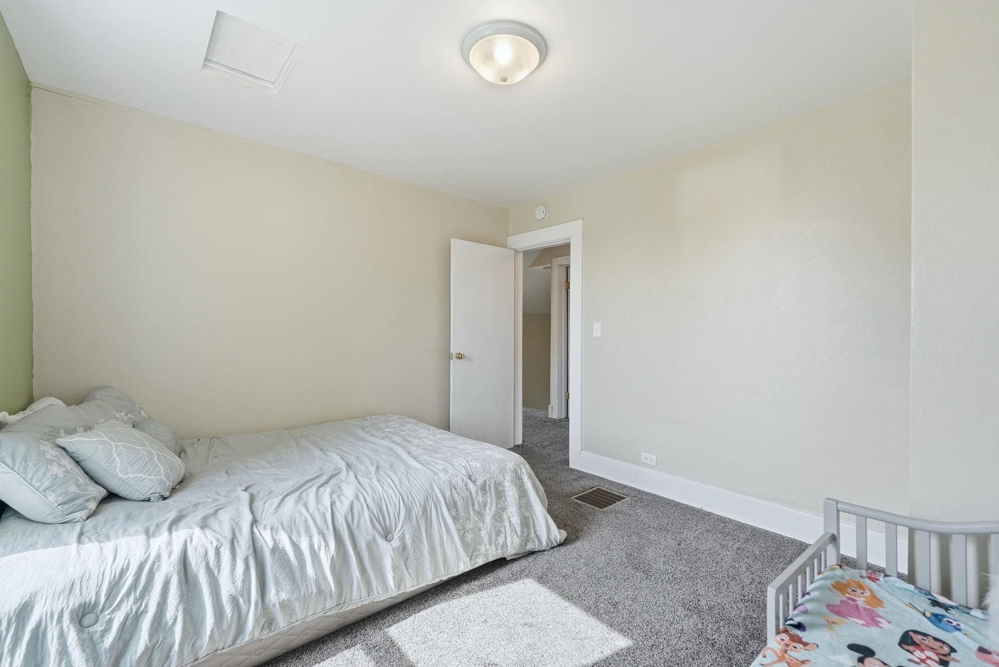 Room featuring light-colored walls, gray carpeting, a flush-mount ceiling light fixture, and white trim