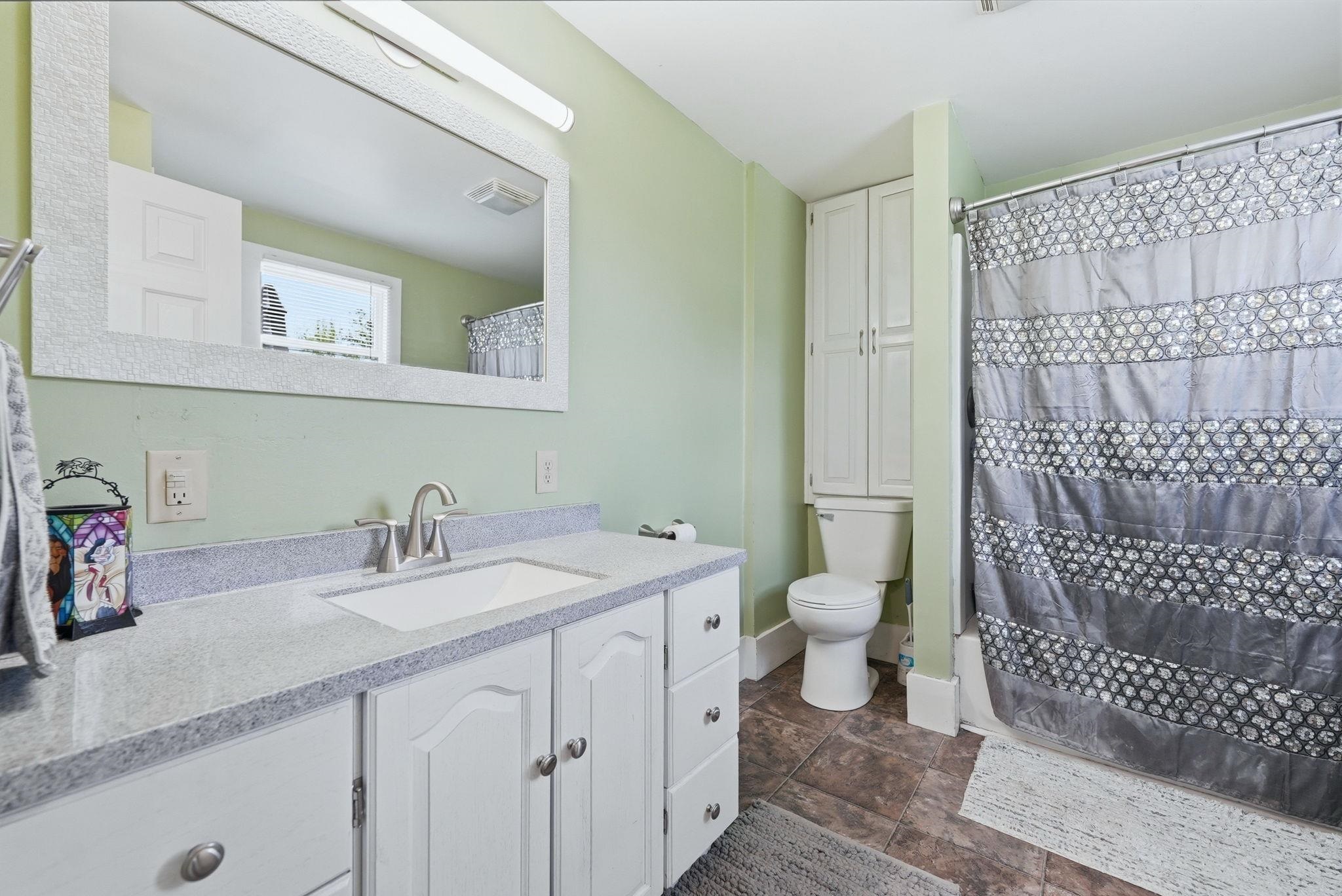 Bathroom vanity featuring a light-colored countertop, integrated sink, and brushed nickel faucet