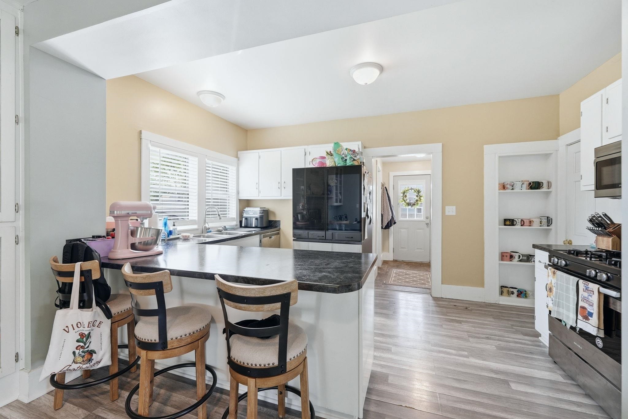 Kitchen featuring white cabinetry and wood-finish flooring