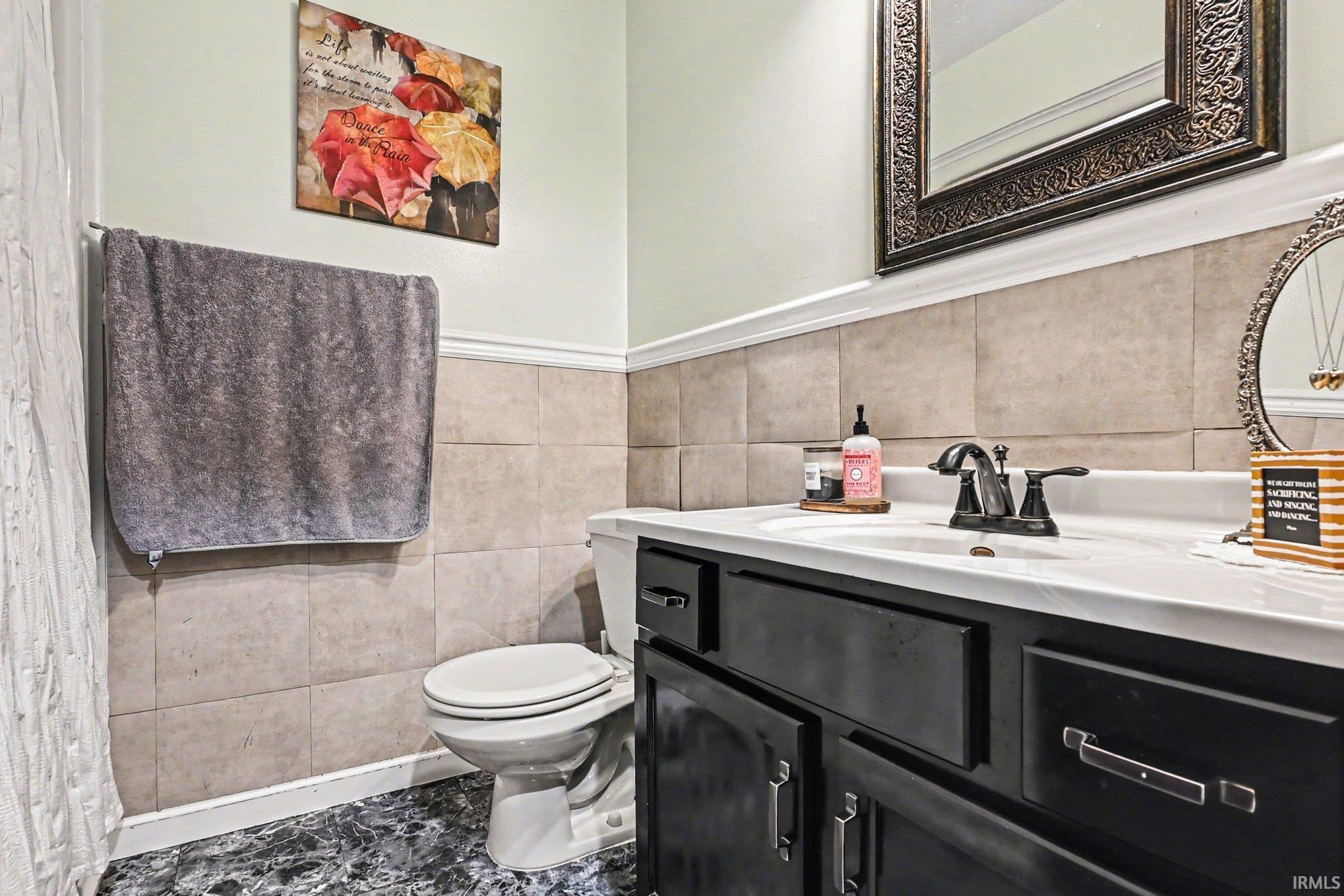 Bathroom vanity featuring a white countertop with an integrated sink and black cabinetry
