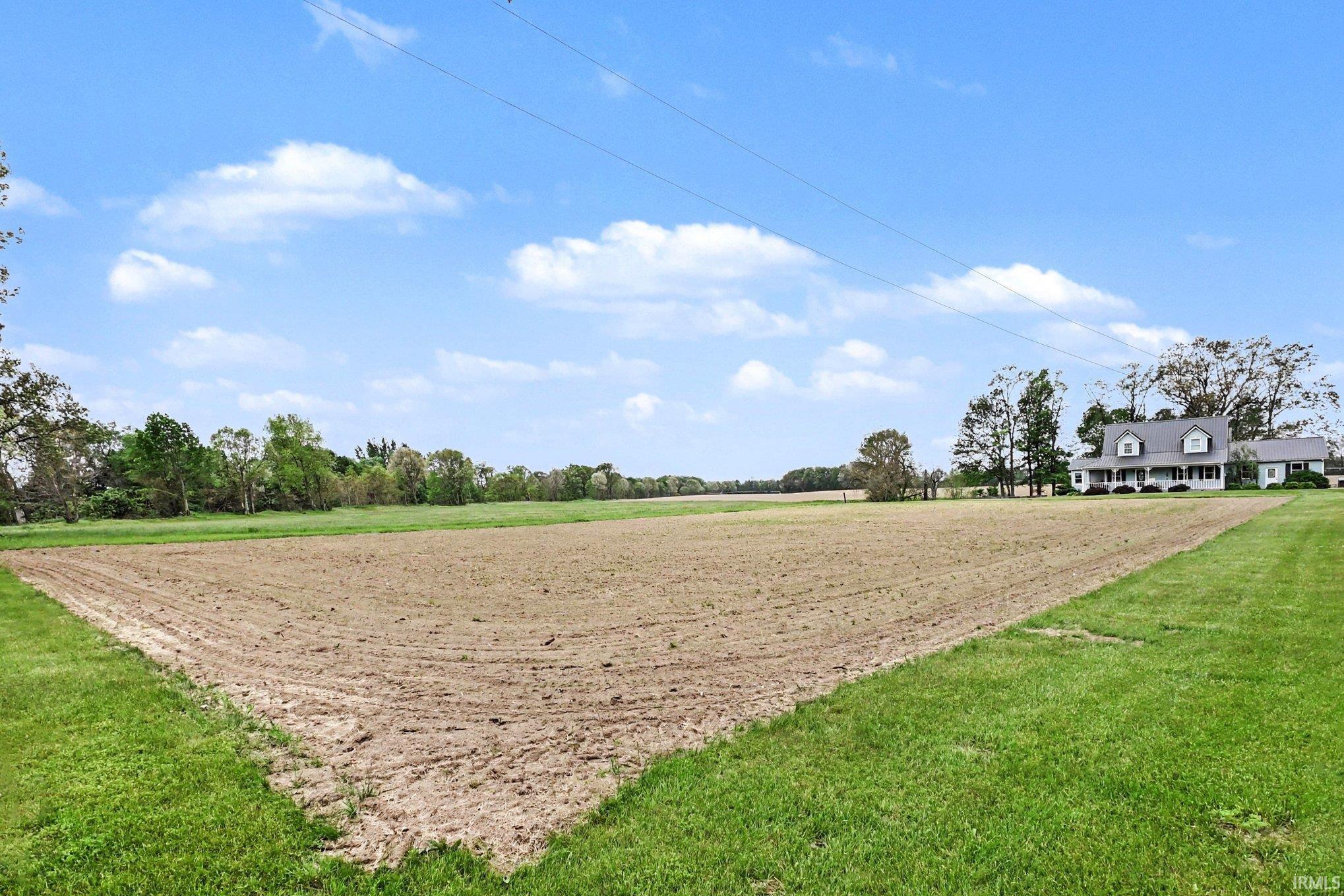 Expansive cultivated land parcel bordered by manicured green grass