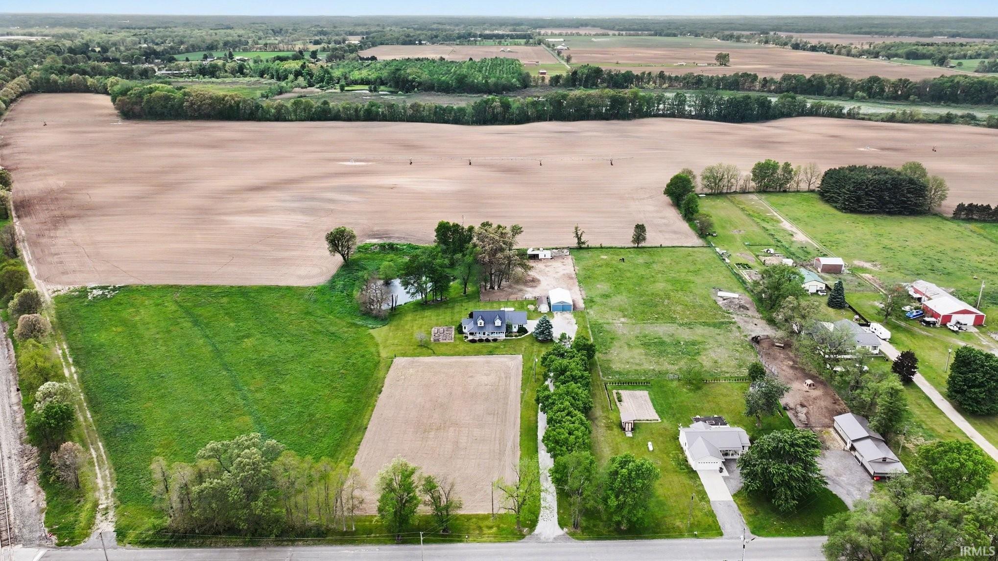 Expansive rural property featuring substantial acreage, a single-family residence with a detached garage, and a private pond