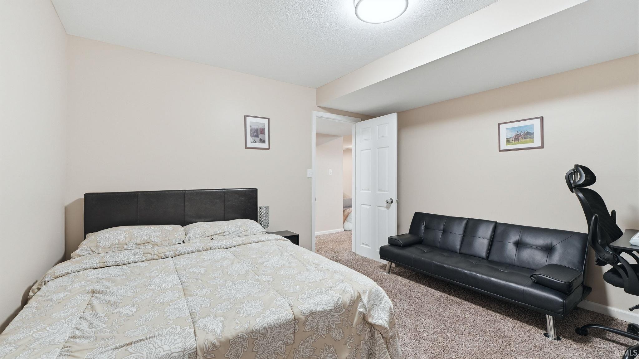 Neutral-toned walls complement the textured carpet flooring