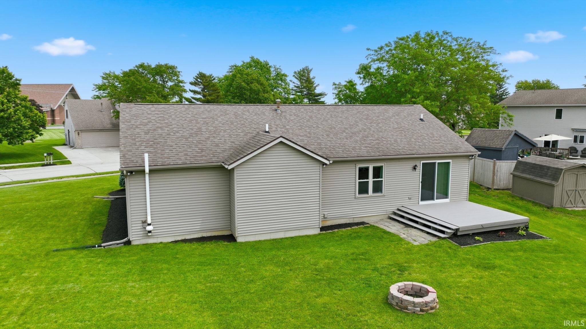 Rear exterior featuring light gray siding, a composite deck with steps, and a sliding glass door