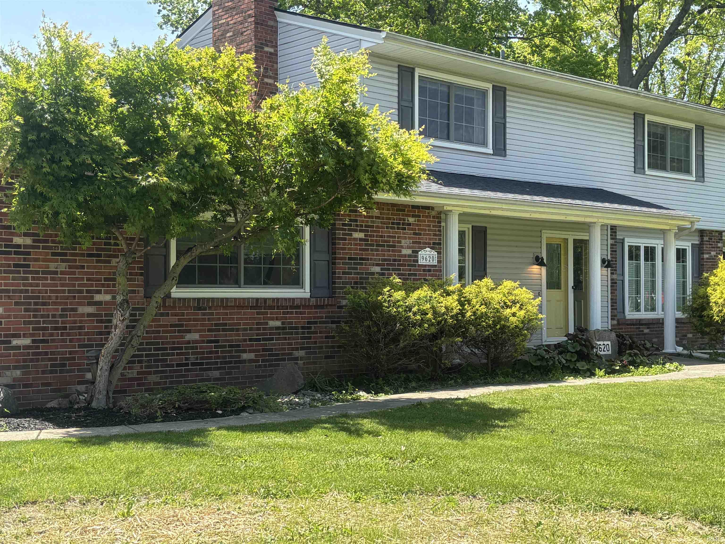 Traditional two-story residence featuring a brick and siding exterior