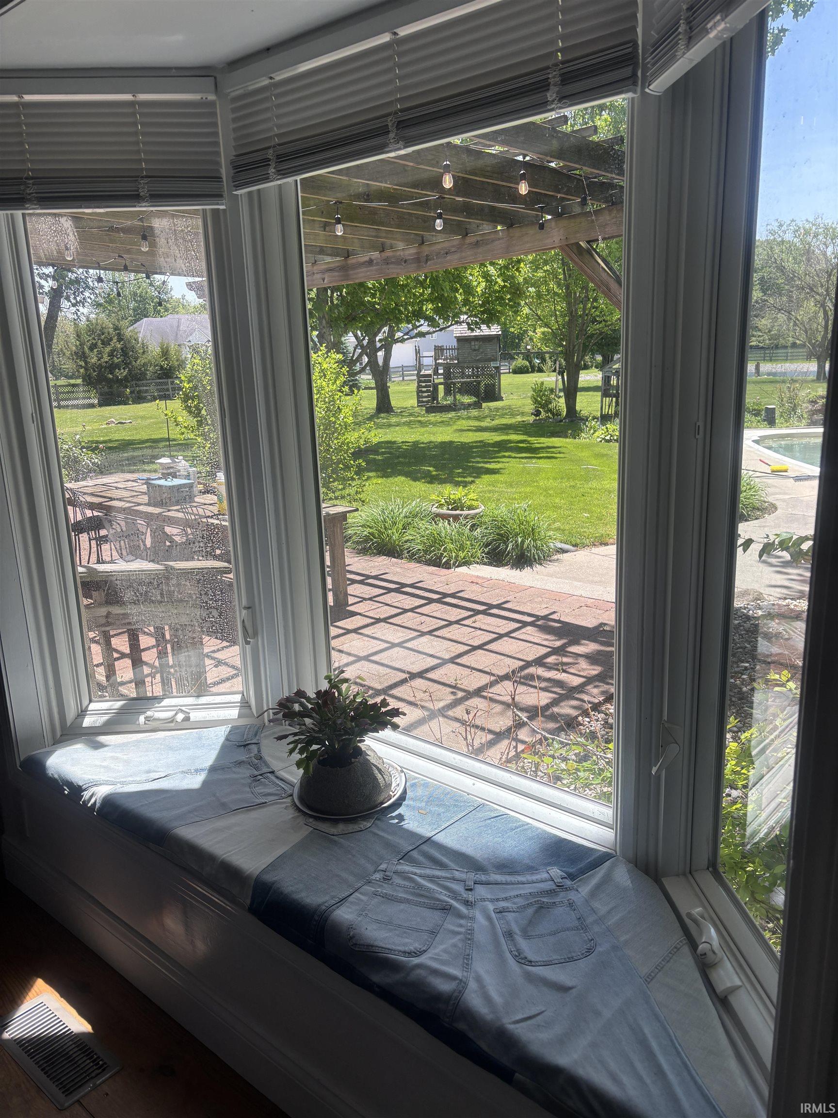 Bay window with integrated window seat overlooking a spacious backyard