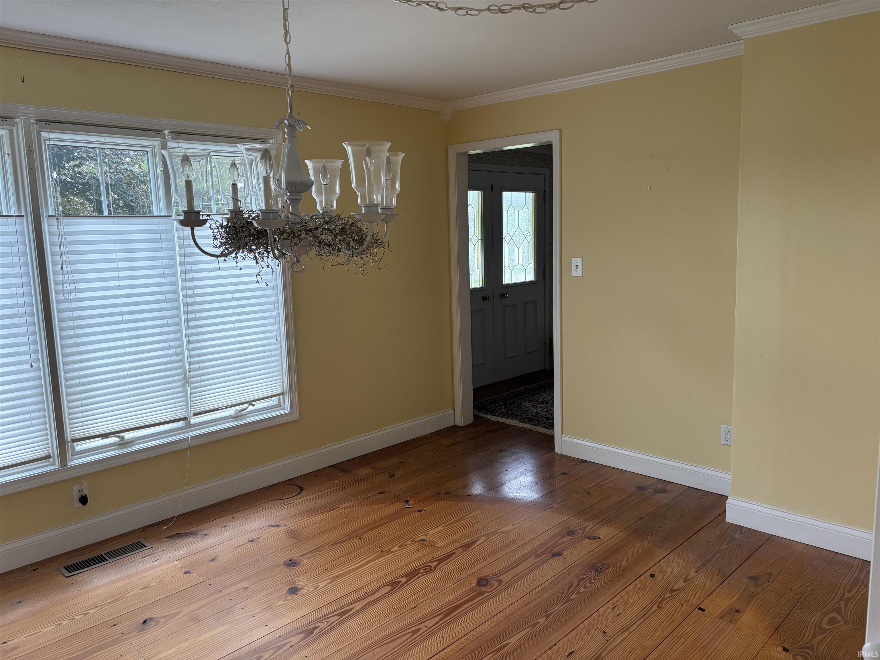 Wood-finish flooring throughout, complemented by a decorative chandelier