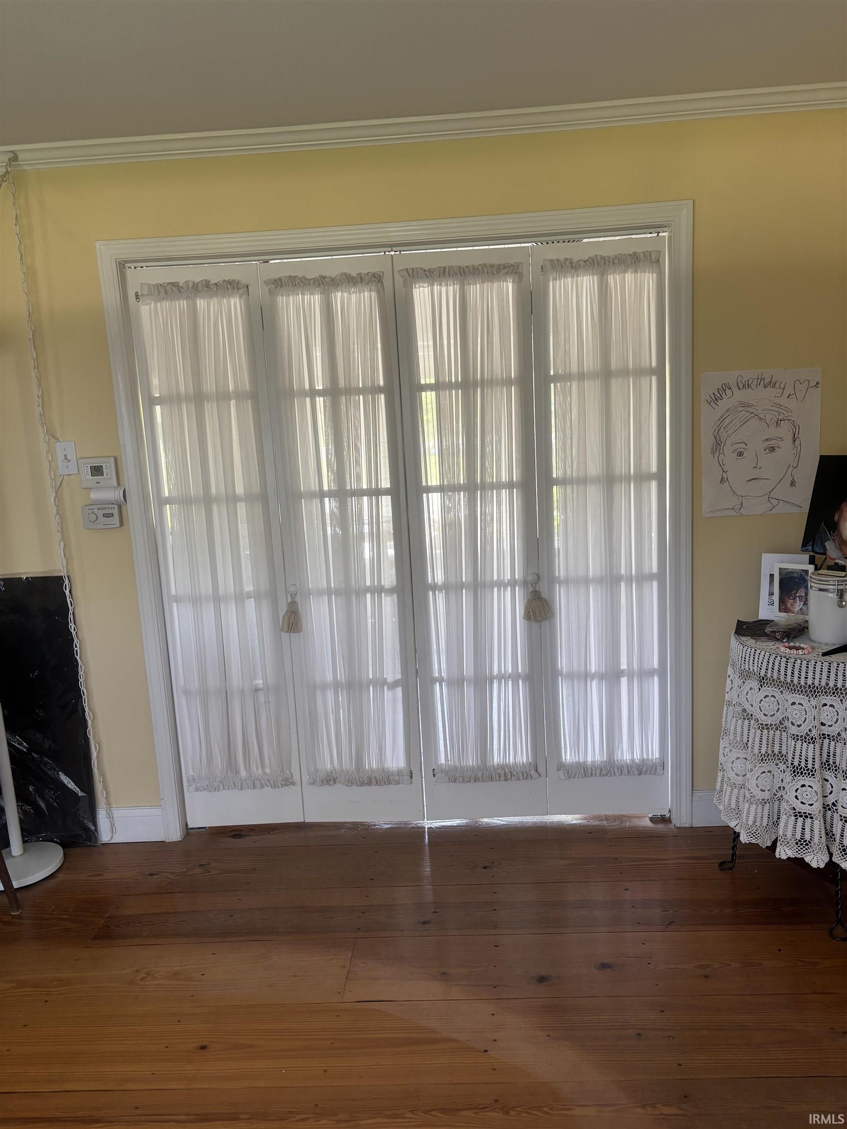 Double French doors with sheer white privacy curtains
