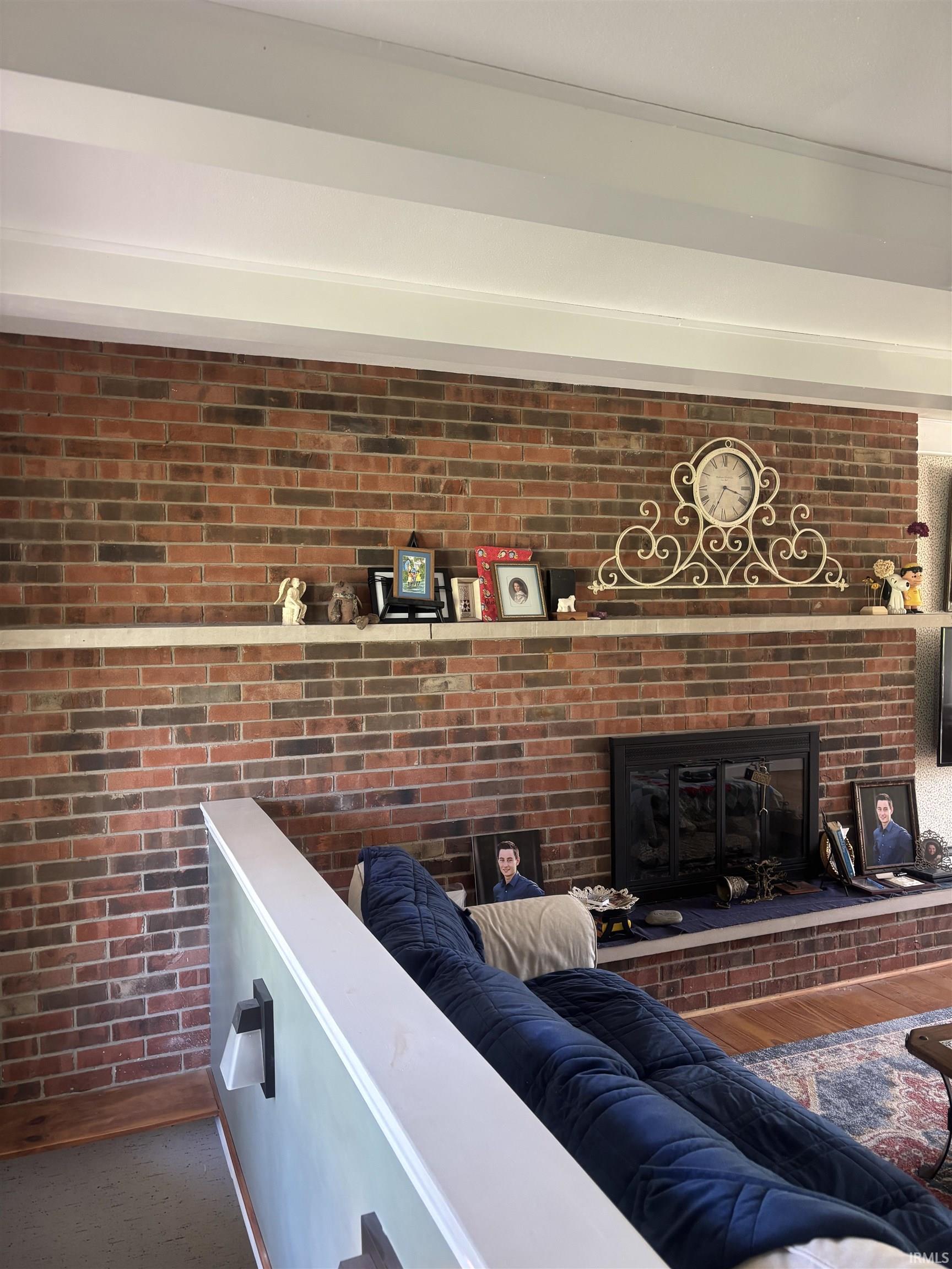 Brick fireplace with a black firebox and a white mantel shelf