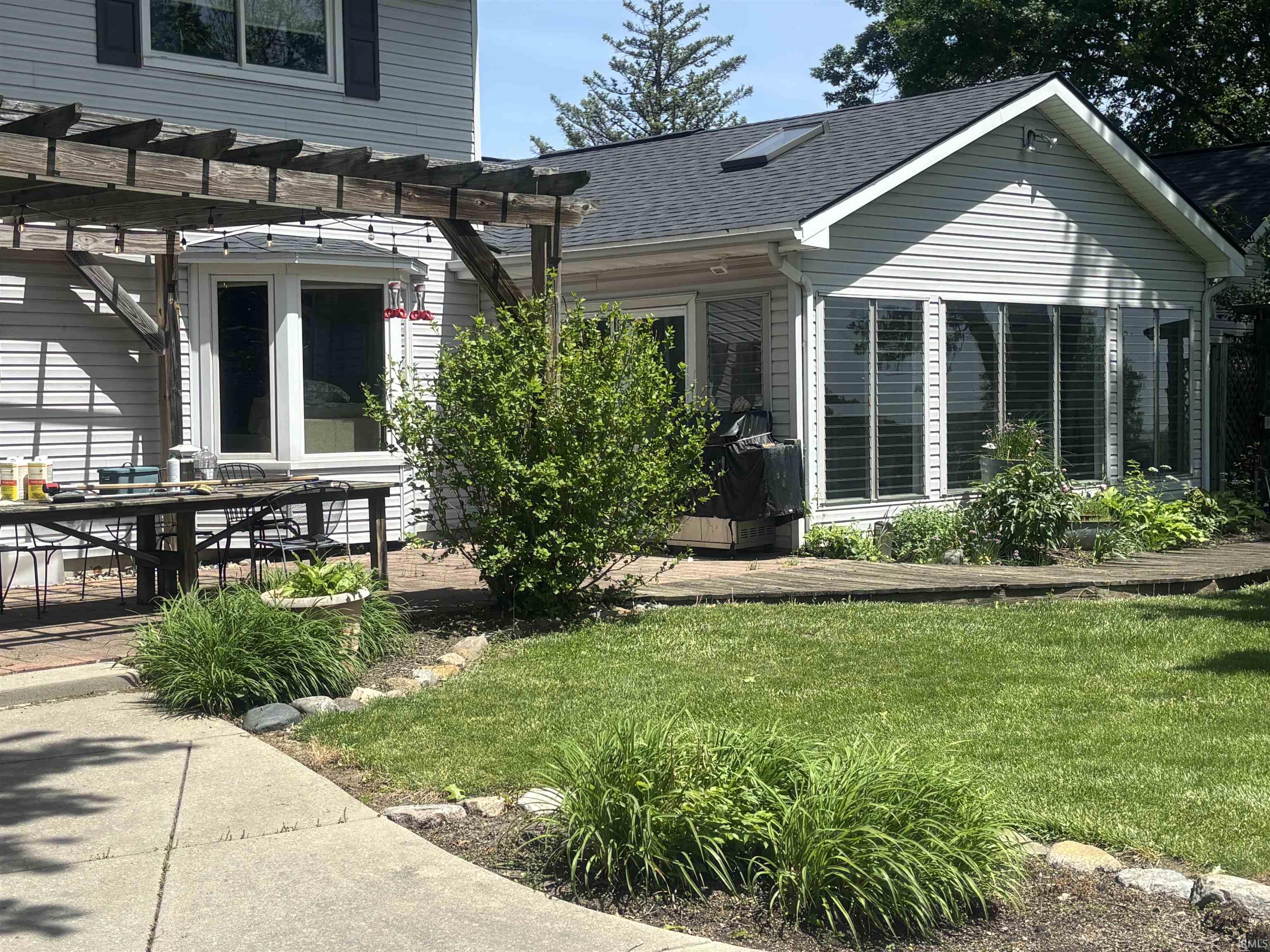 Exterior featuring siding, multiple windows with horizontal blinds, and a gabled roof