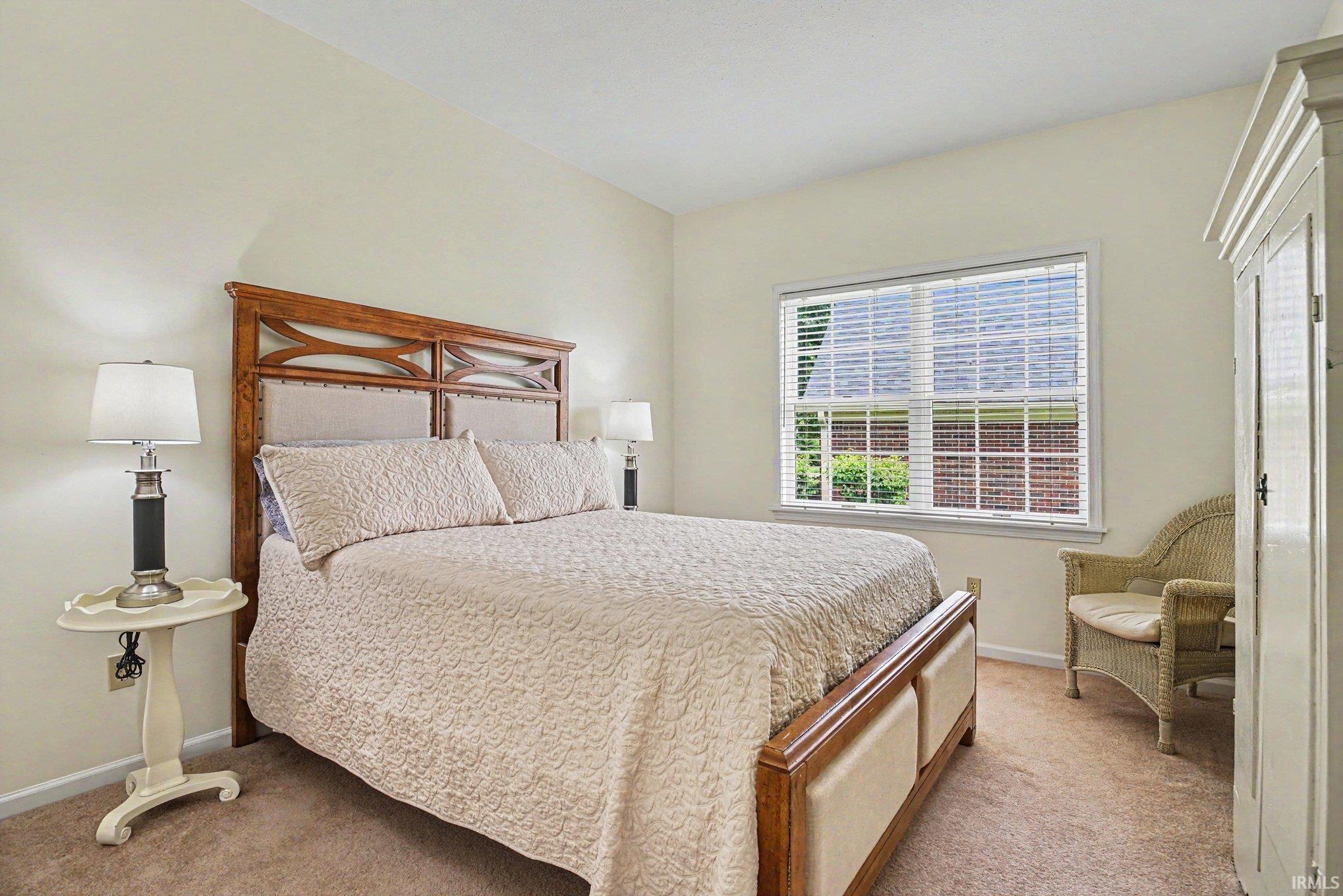 Carpeted room featuring light-colored walls and a window with horizontal blinds