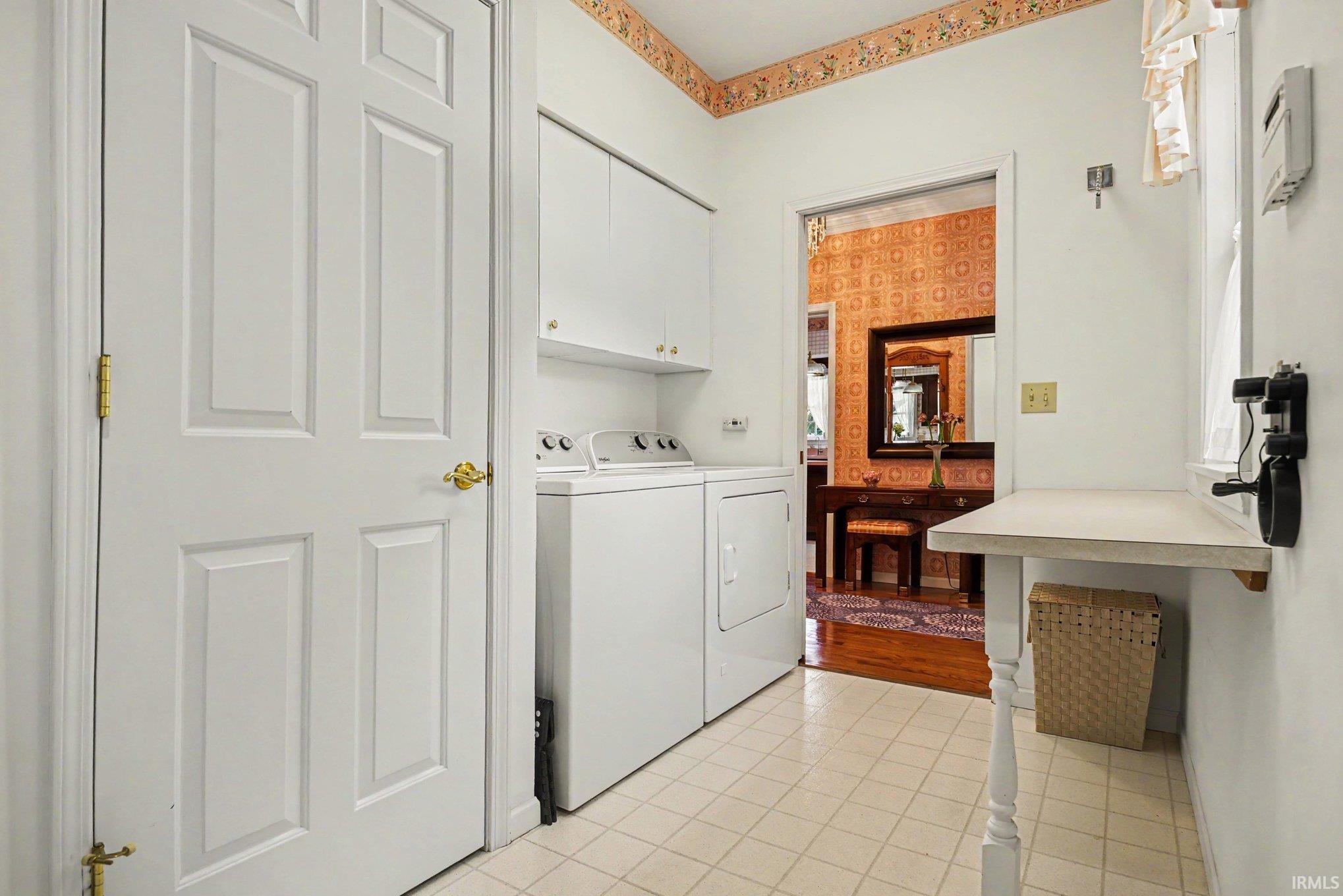 Main level laundry area with a folding table and wall mounted ironing board