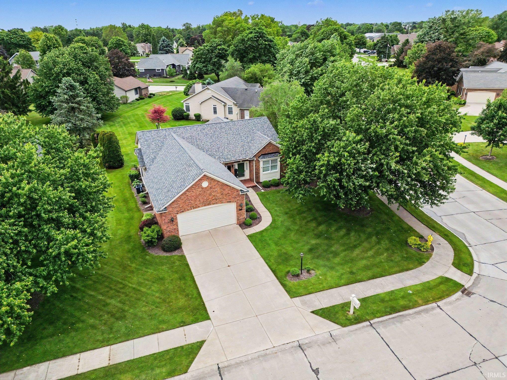 Brick ranch-style residence featuring a prominent front-facing garage