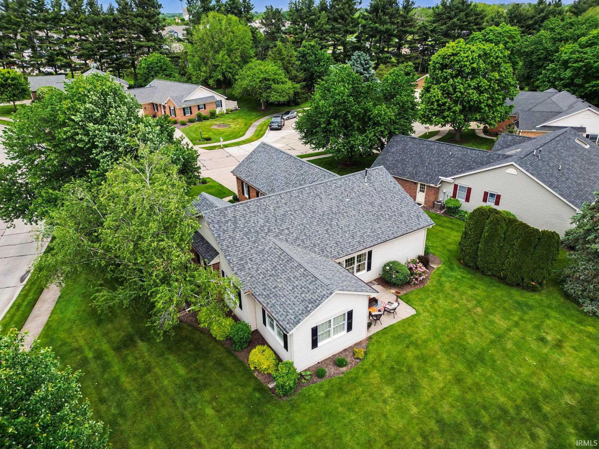 Ranch-style residence featuring a gray shingle roof and light-colored siding