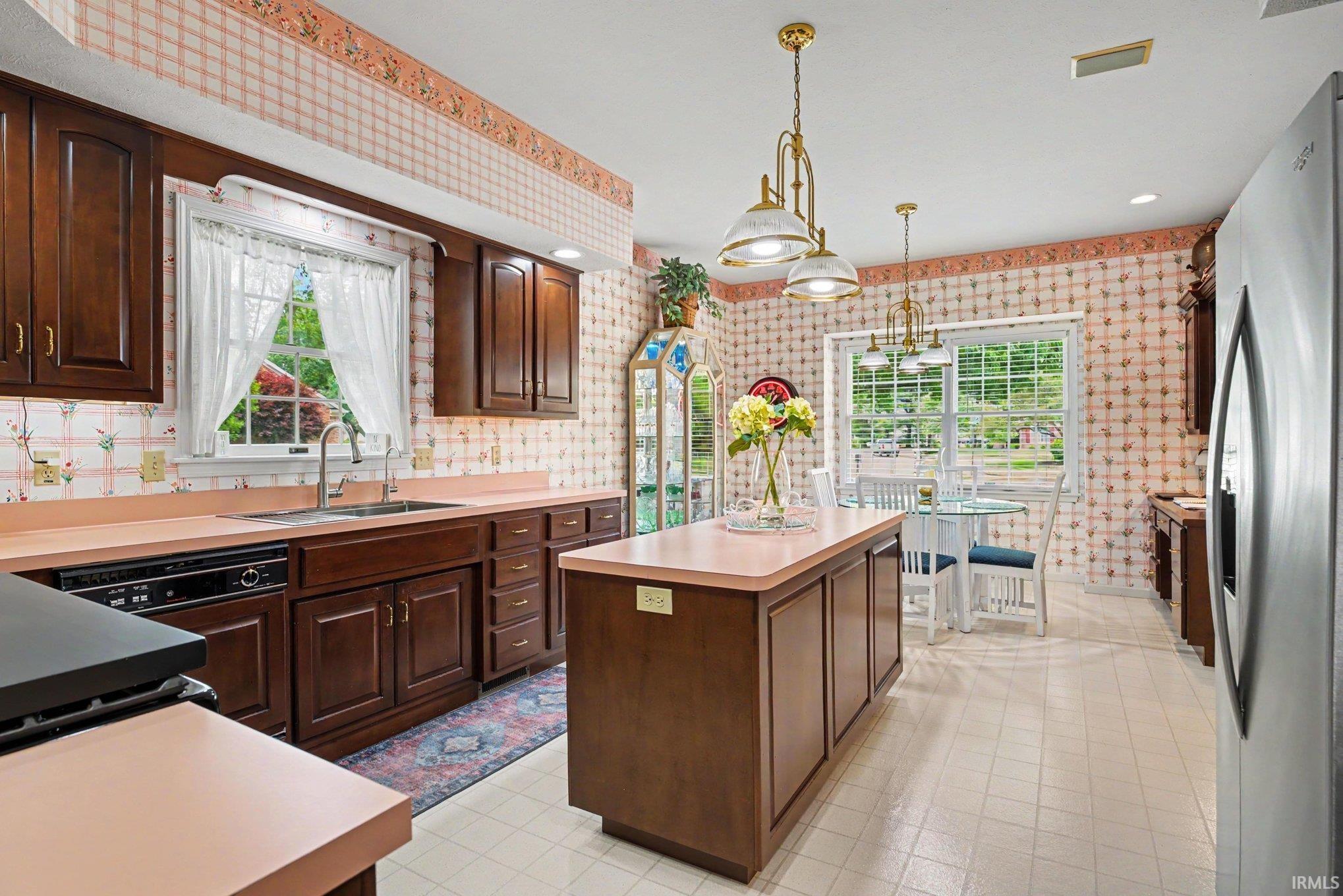 Kitchen featuring wood cabinetry, light countertops, and a central island