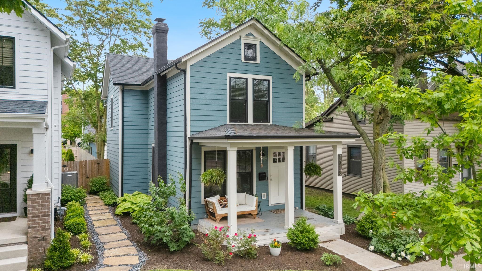 Two-story residence featuring blue horizontal siding and a dark shingled roof