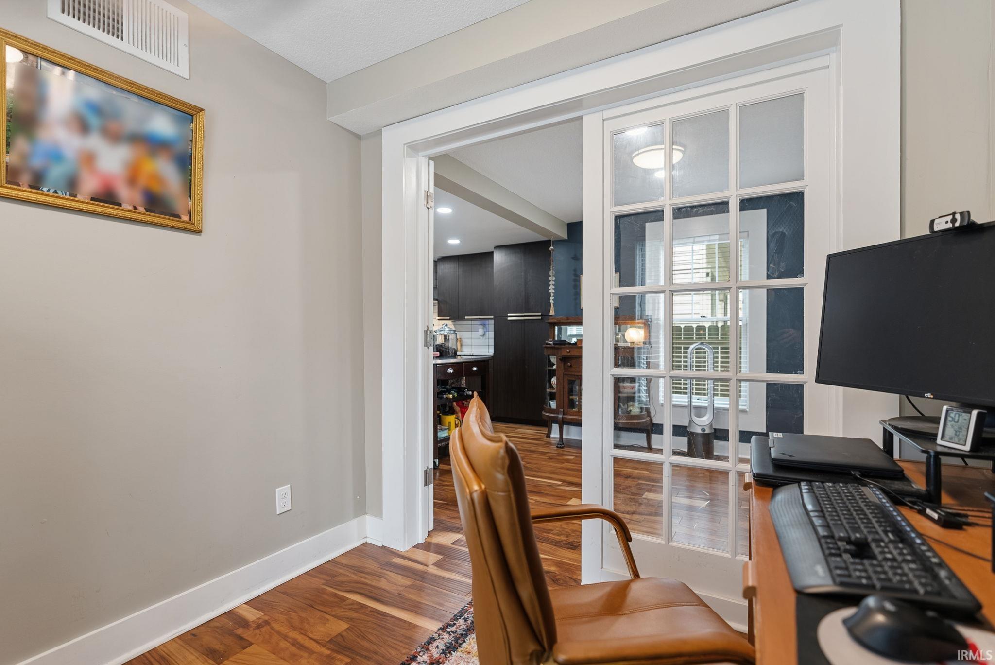 Interior space featuring wood-finish flooring, white baseboards, and neutral wall paint
