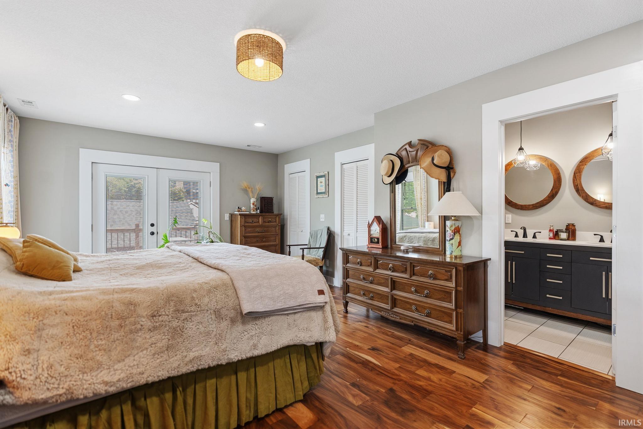 Spacious room featuring wood-finish flooring, recessed lighting, and a contemporary ceiling fixture