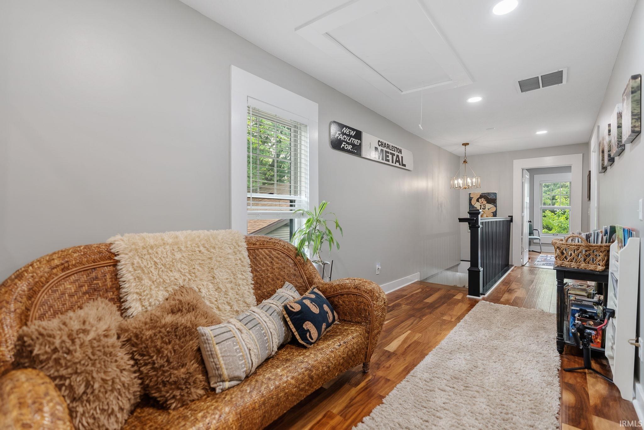 Hallway featuring rich wood-finish flooring and light gray walls