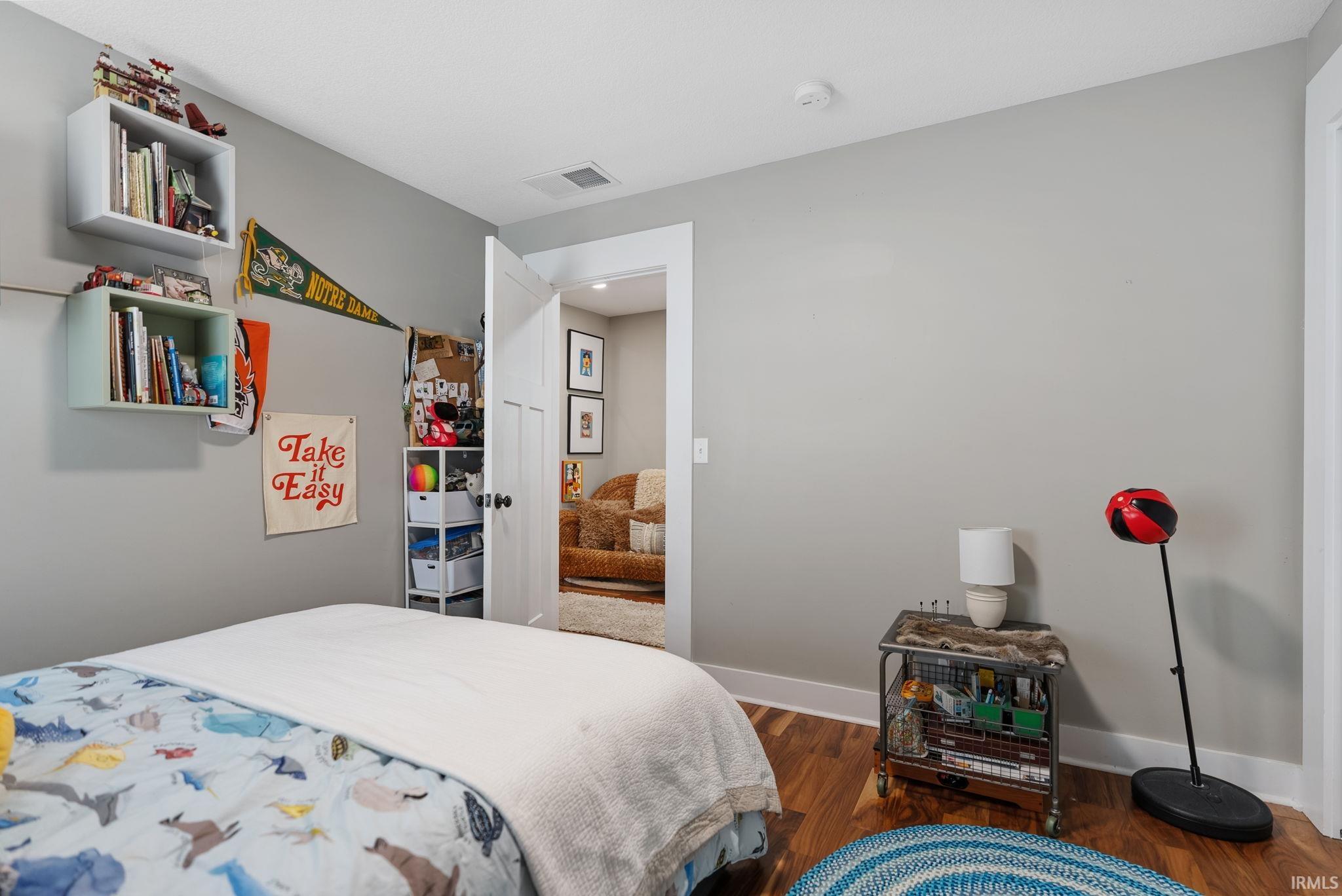 Room featuring wood-finish flooring, light gray wall paint, and white trim