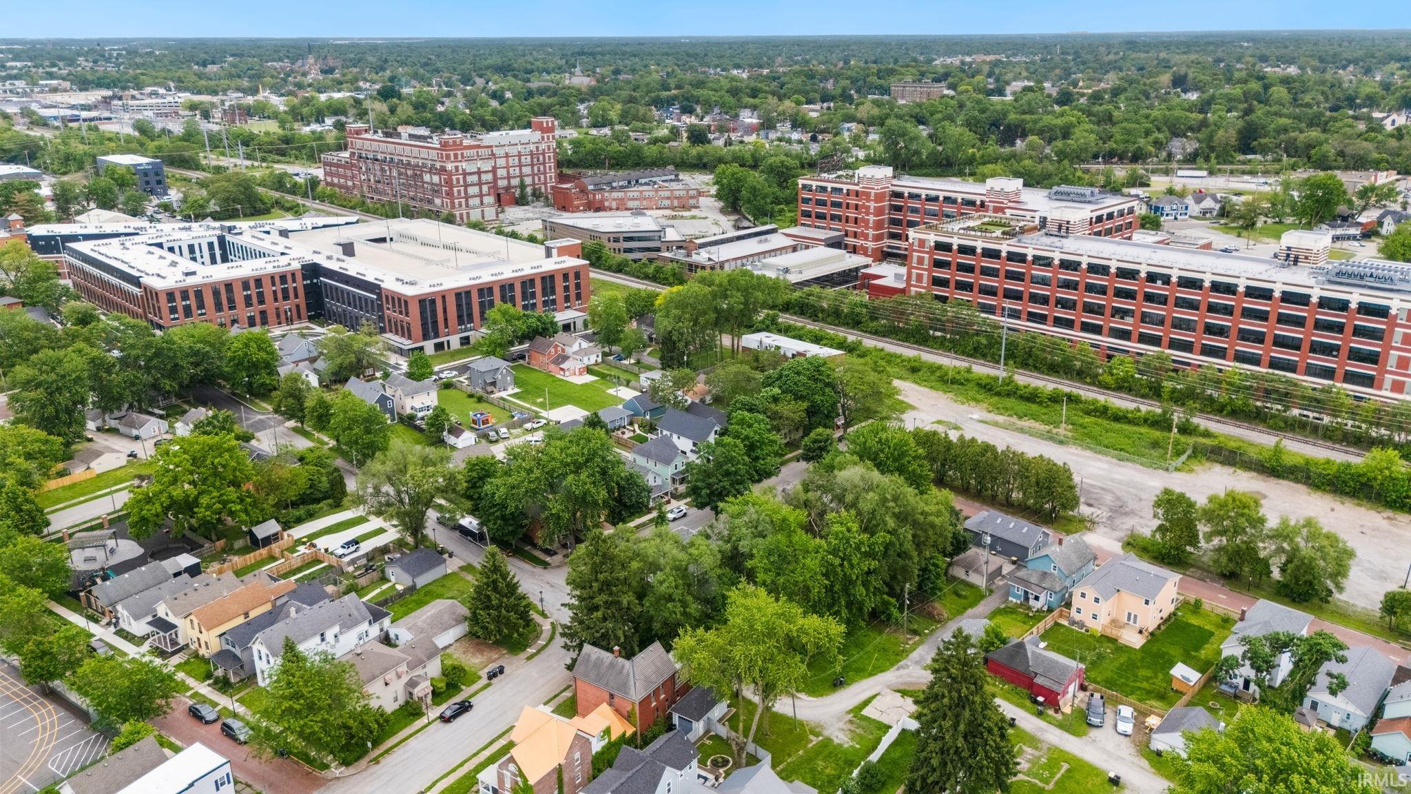 Aerial perspective showcasing a residential area with mature trees, established homes, and nearby urban structures
