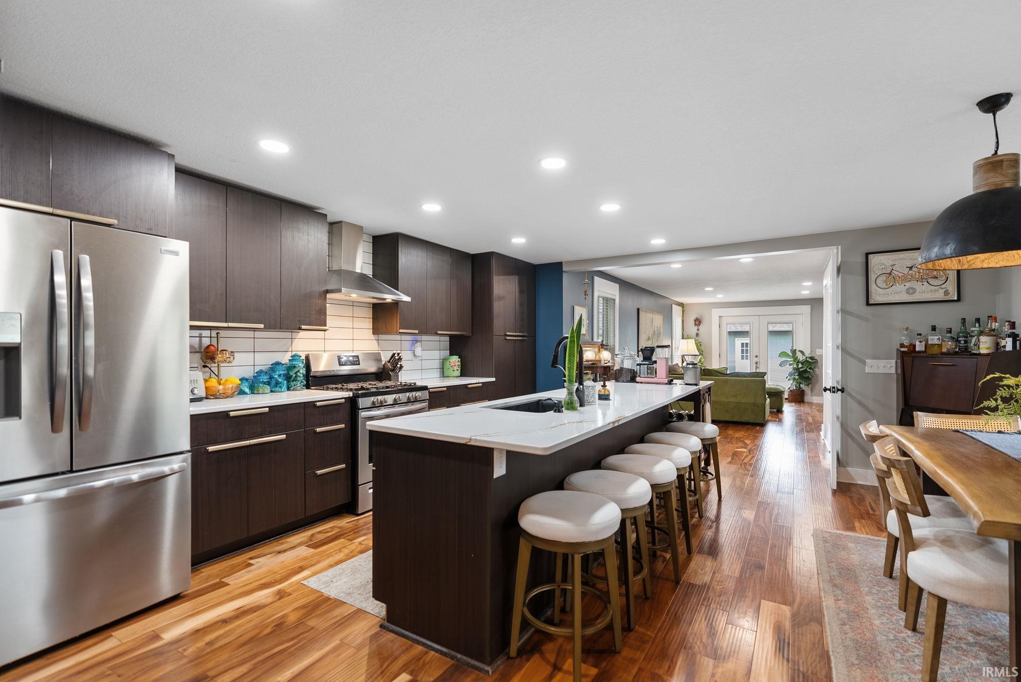 Spacious kitchen featuring rich wood-finish cabinetry and a large center island with seating