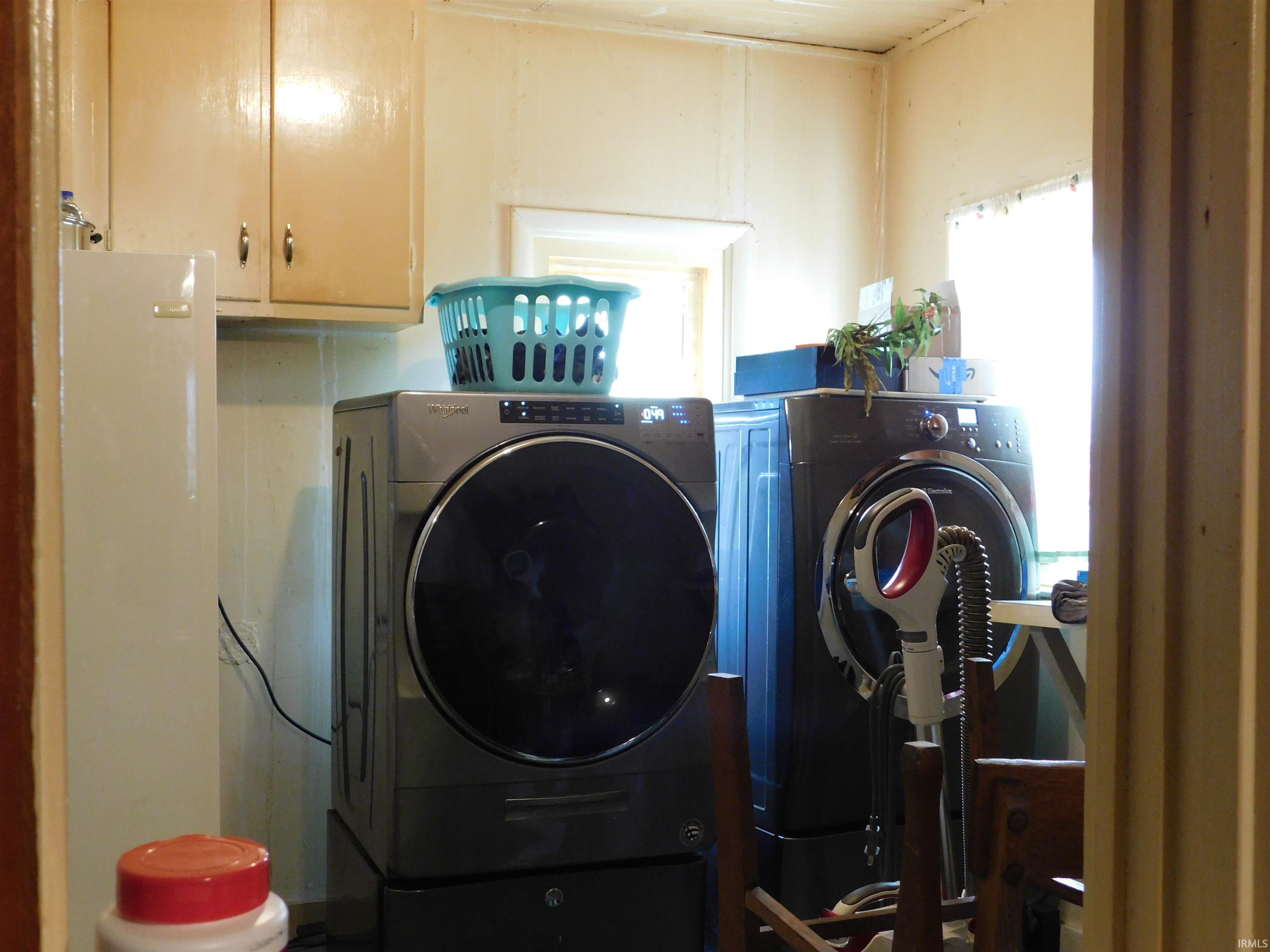 Utility room featuring overhead cabinetry and a natural light source