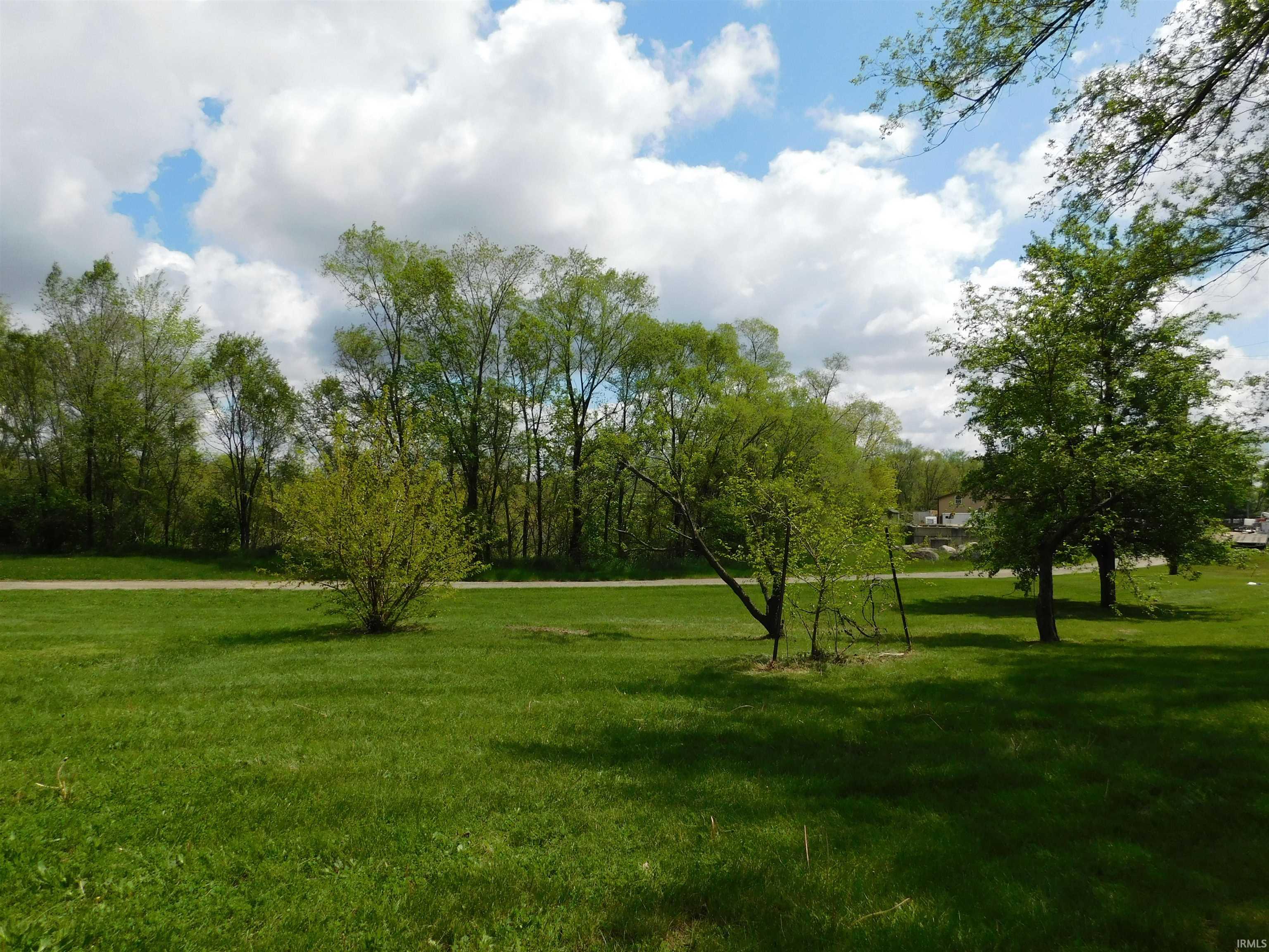 Expansive green lawn with mature trees and natural landscaping
