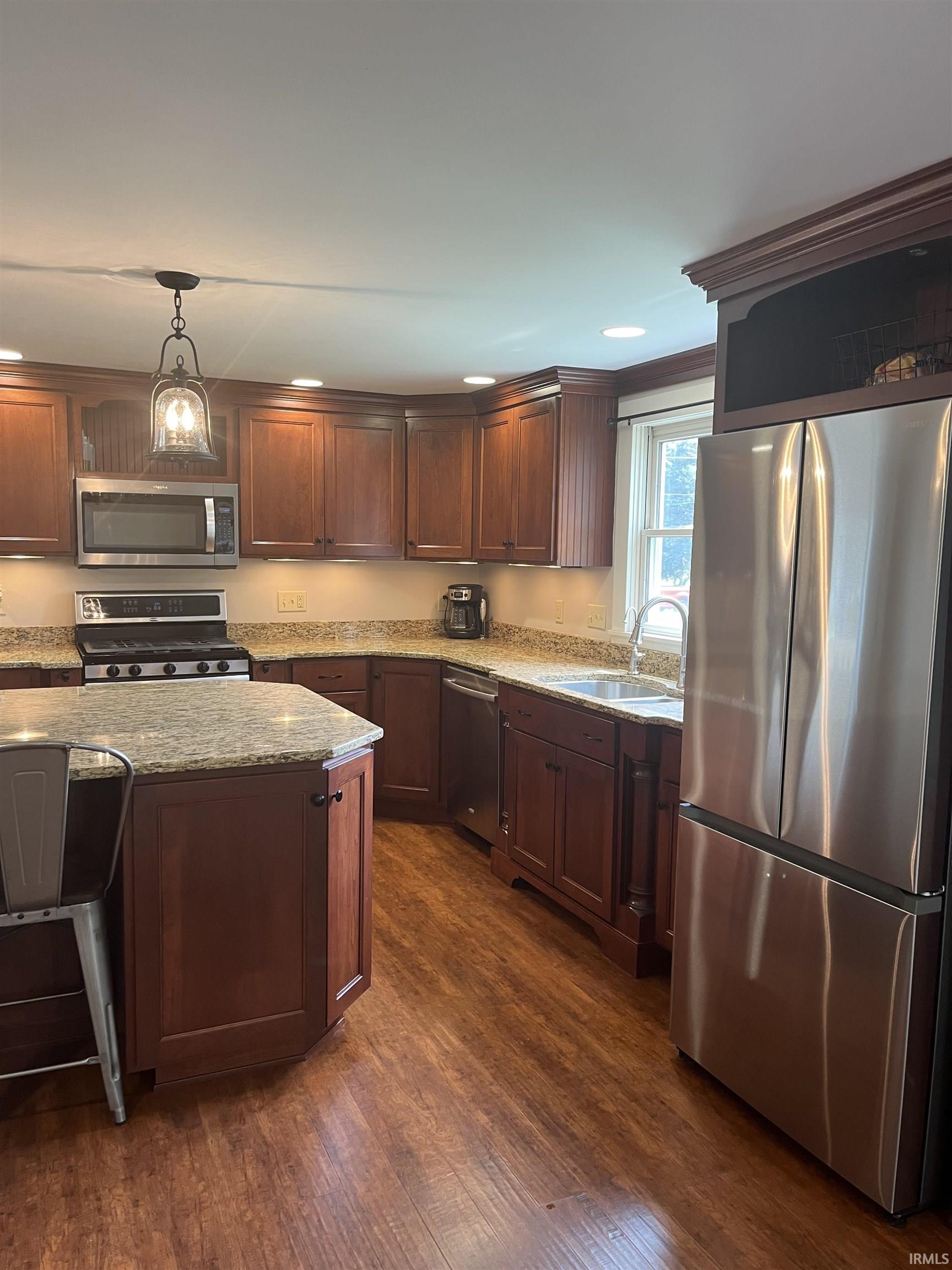Kitchen featuring wood-finish flooring, recessed lighting, and a multi-light pendant