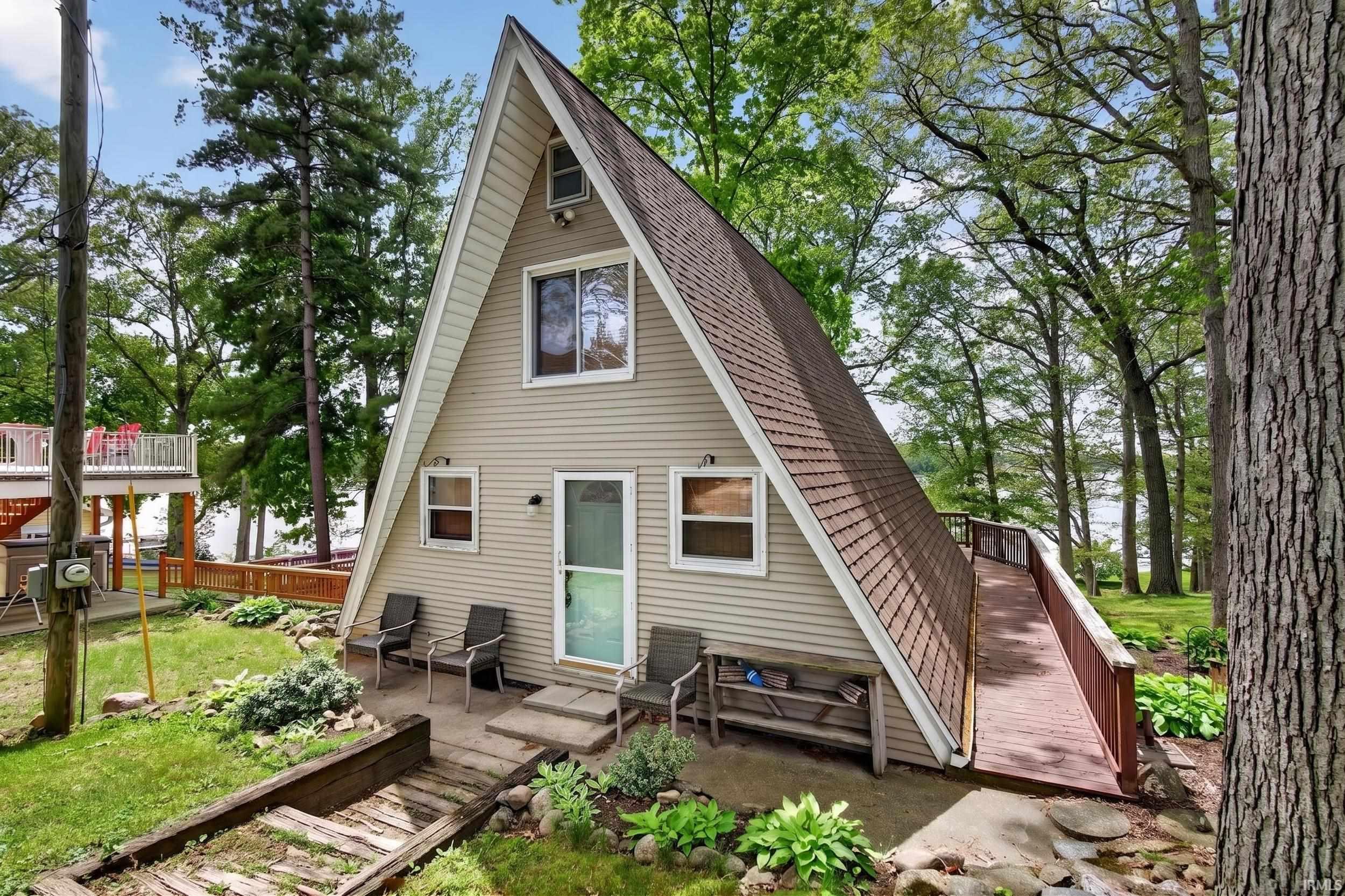A-frame structure featuring light-colored siding and a contrasting brown shingle roof