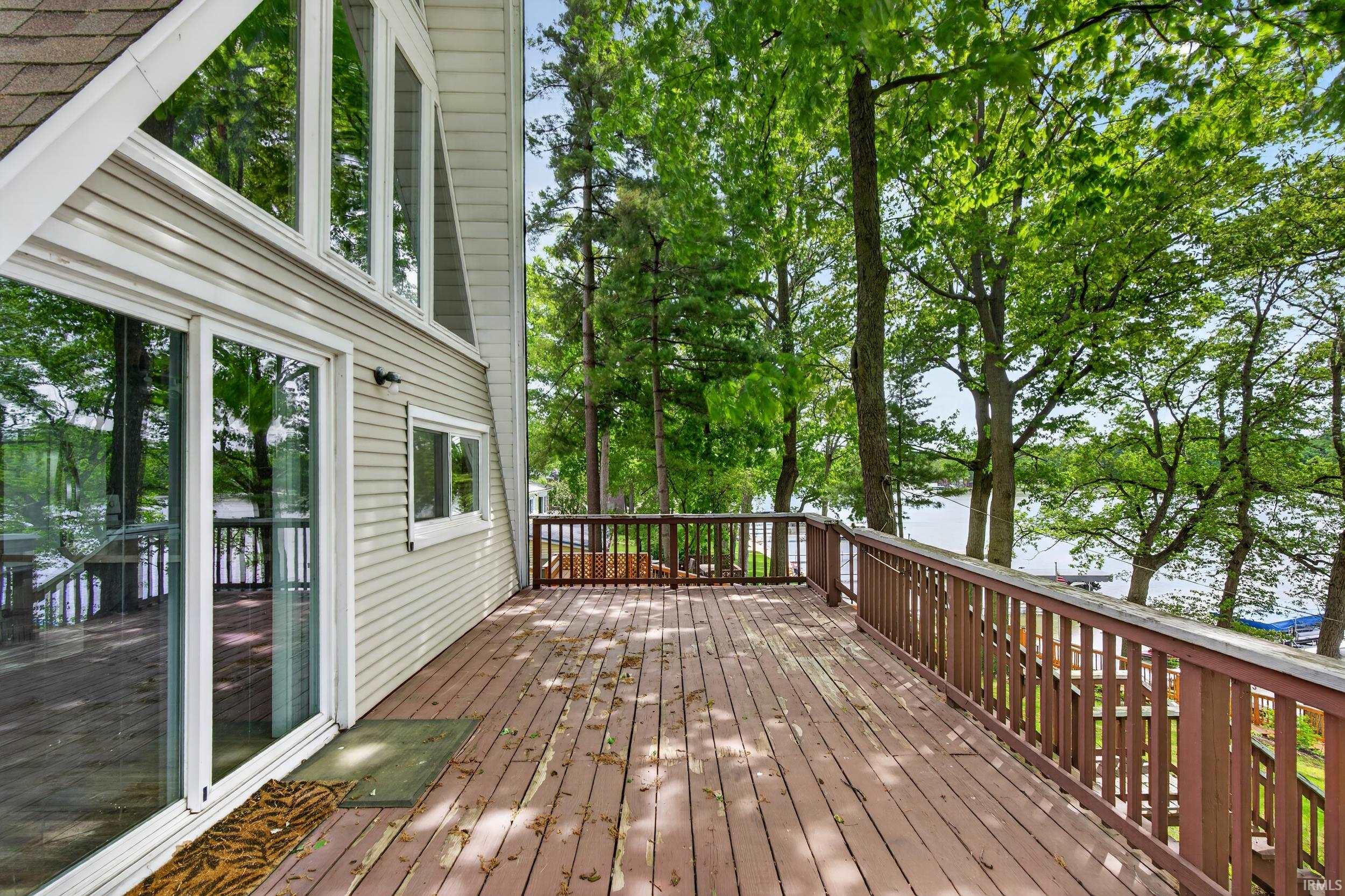 Expansive exterior deck featuring wood-finish flooring and railing