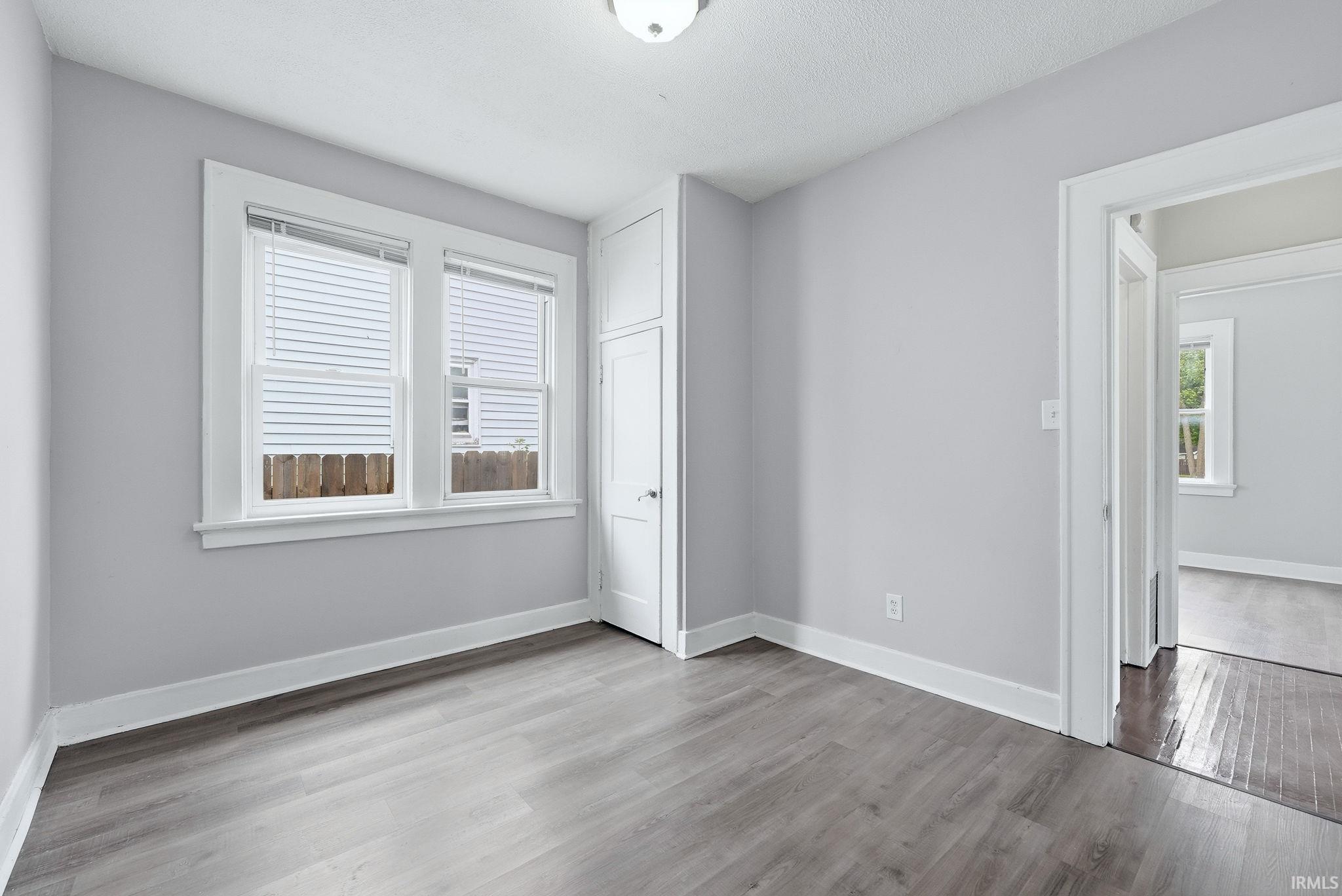Neutral tone walls complement the wood-finish flooring