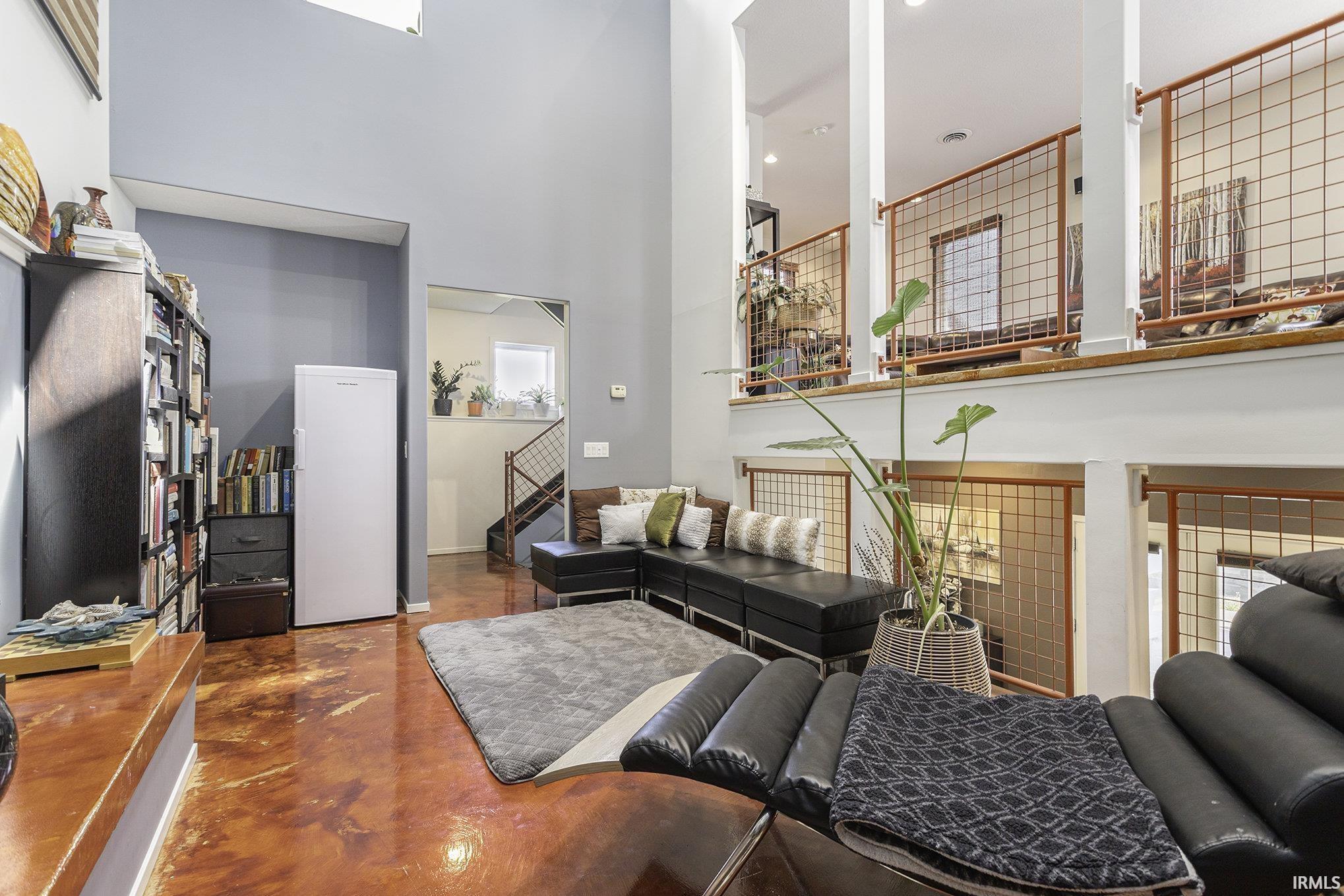Soaring ceilings complement the polished concrete flooring throughout this living space