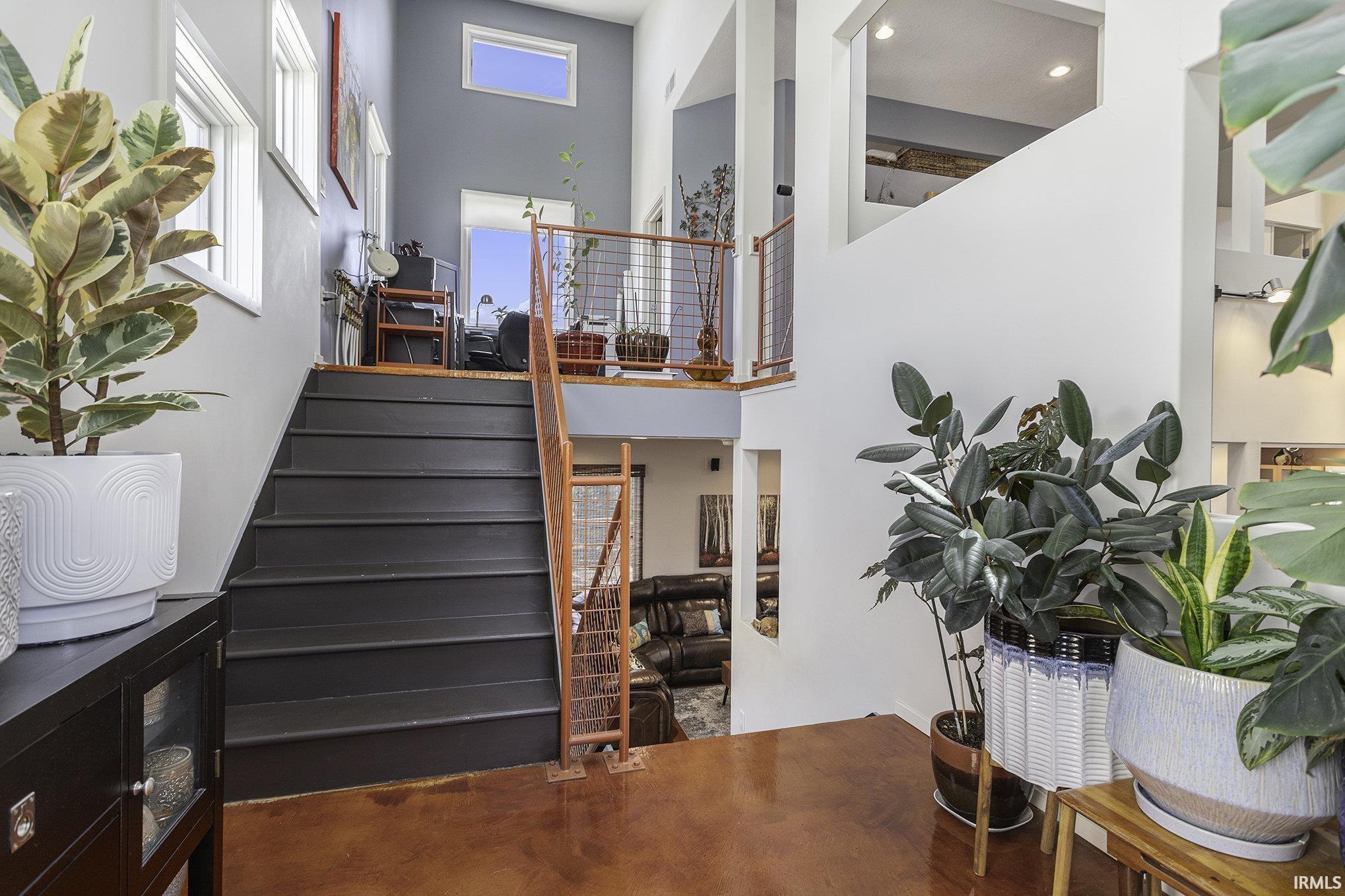 Multi-level interior featuring a contemporary staircase with dark treads and a light wood-finish railing