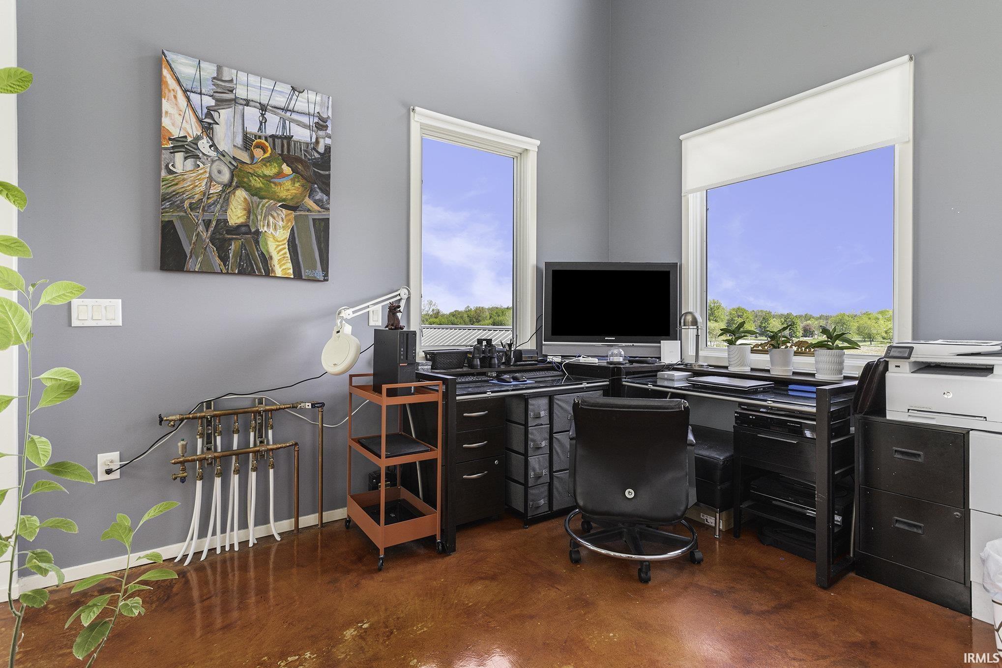 Room with two large windows, gray walls, and a distinctive reddish-brown floor