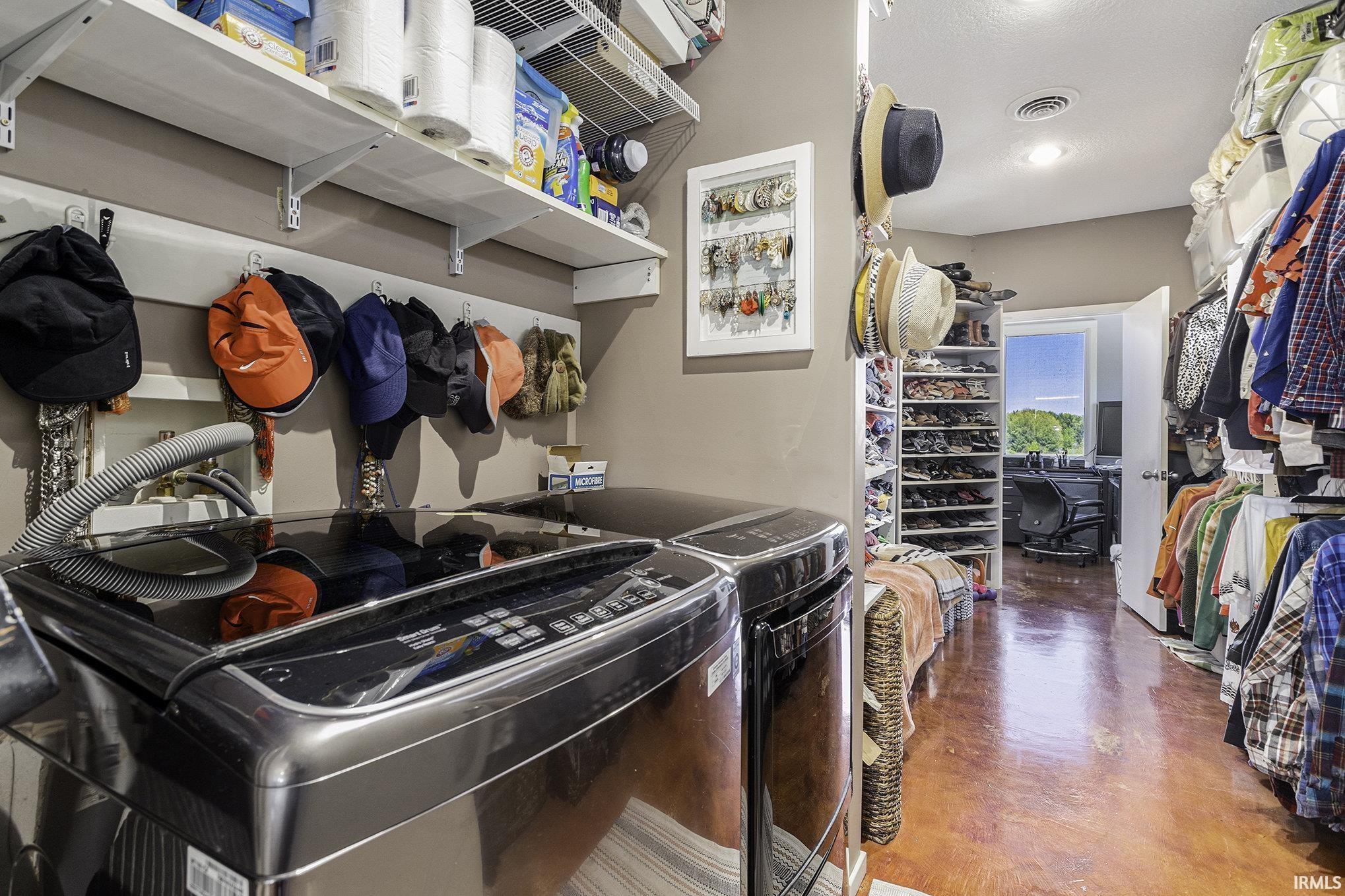 Laundry area with integrated storage and wood-finish flooring