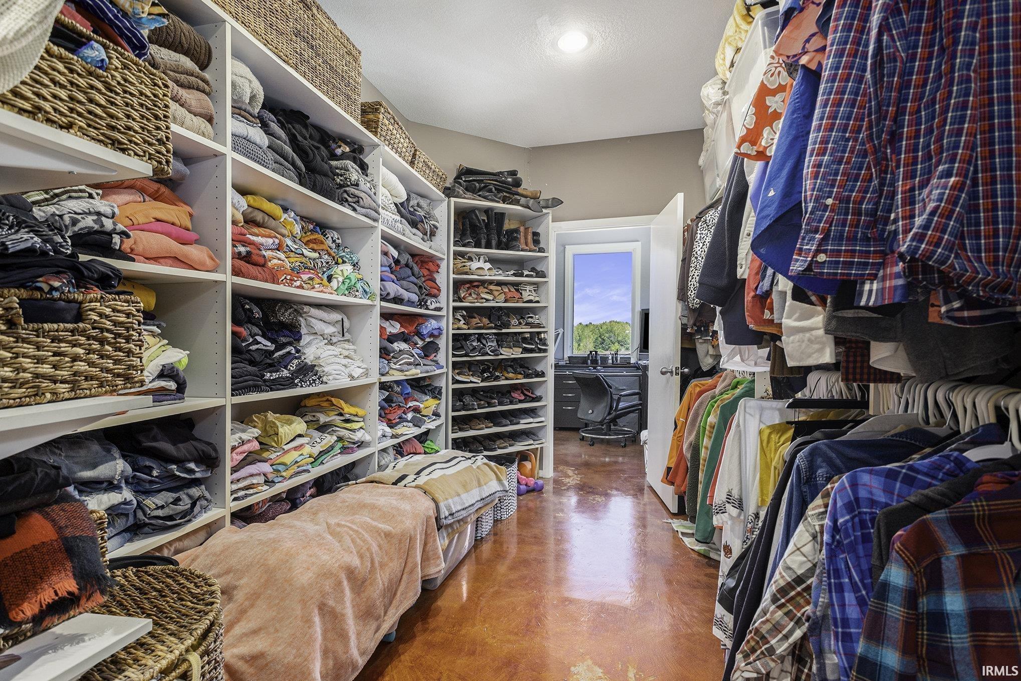 Custom-designed closet featuring extensive built-in shelving, dedicated hanging rods, and integrated shoe storage