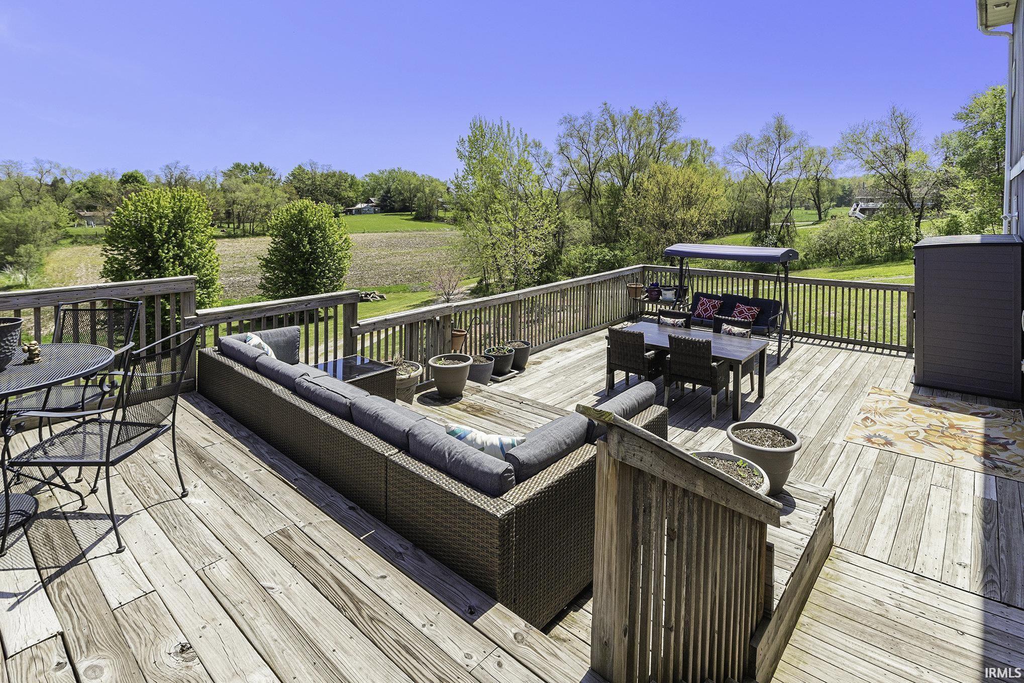 Expansive multi-level wood deck featuring a full railing system and direct access to the surrounding landscape
