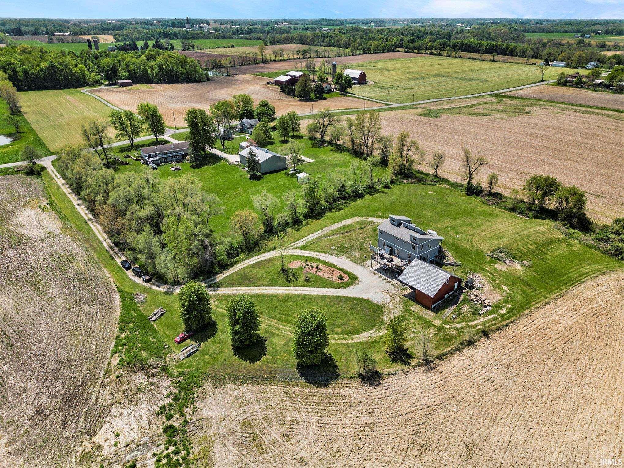 Expansive rural property featuring multiple structures, including a primary residence, a red barn, and additional outbuildings