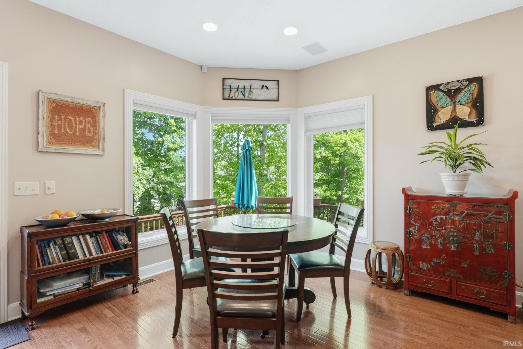 Dining area featuring hardwood flooring, recessed lighting, and a bay window with multiple panes