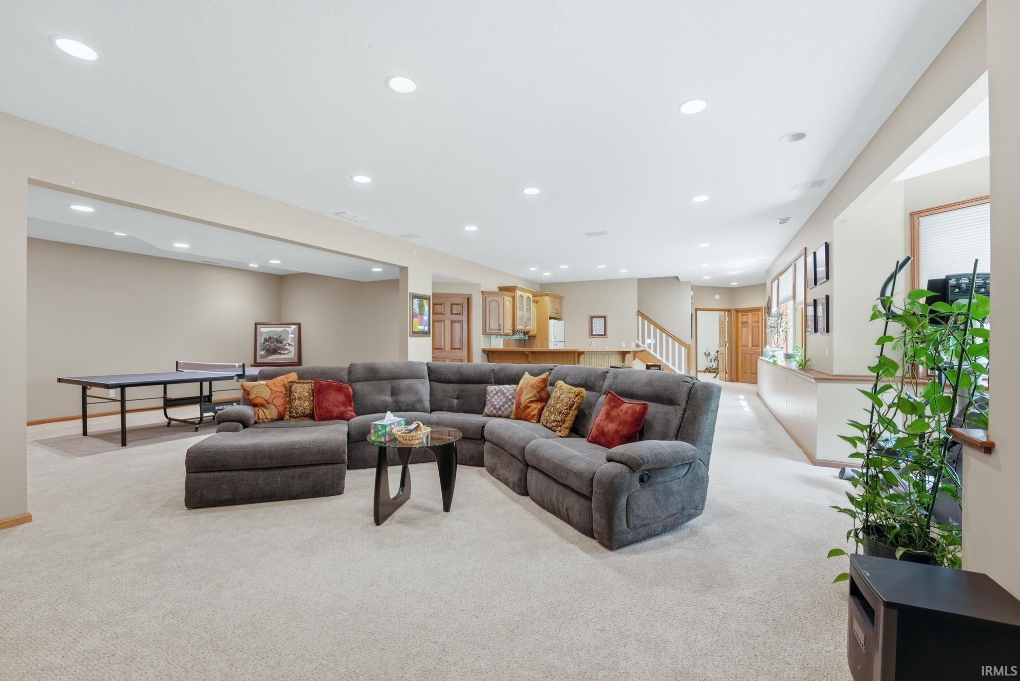 Spacious lower-level entertainment area featuring recessed lighting, light-toned carpeting, and neutral wall tones