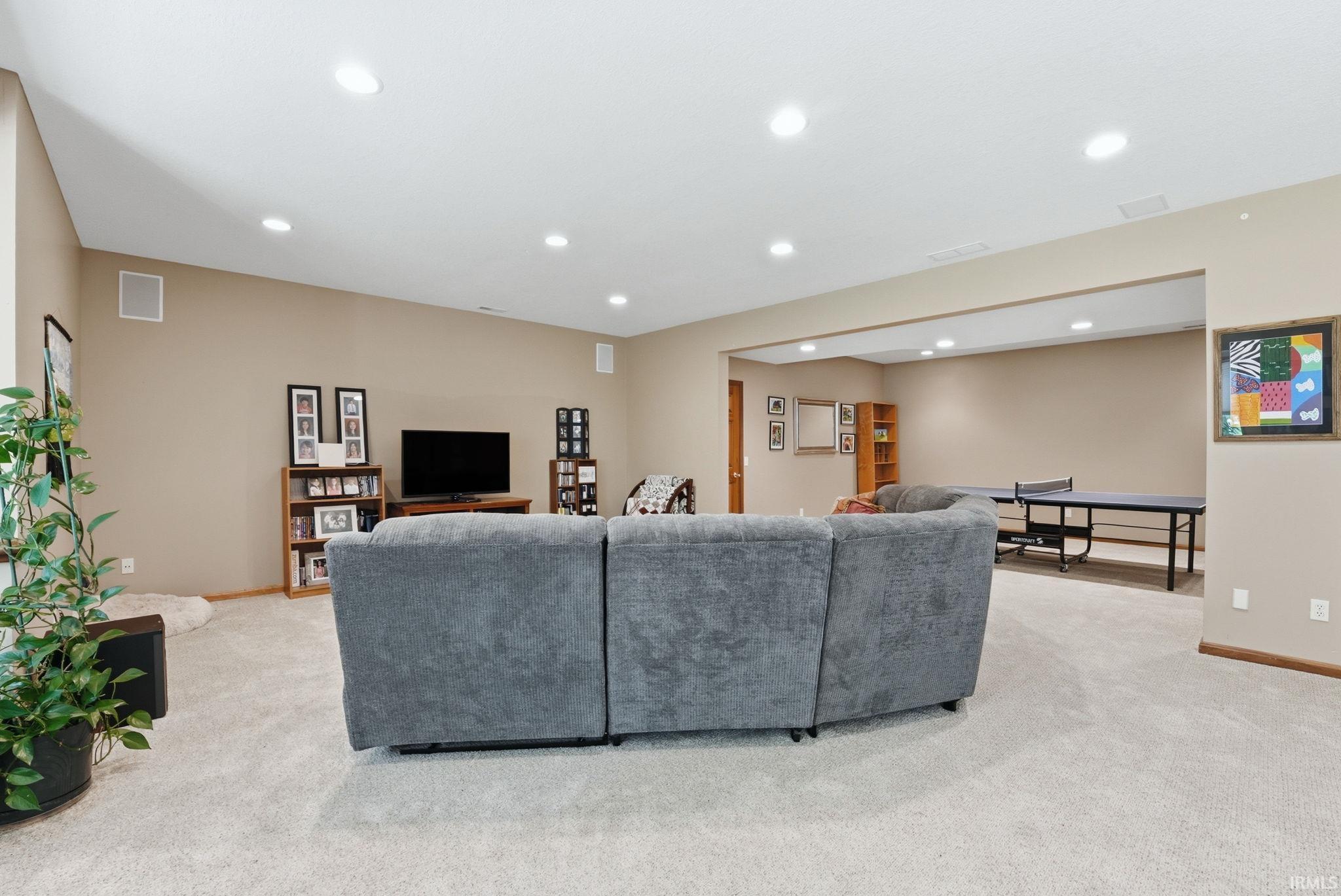 Spacious carpeted room featuring recessed lighting and integrated ceiling speakers