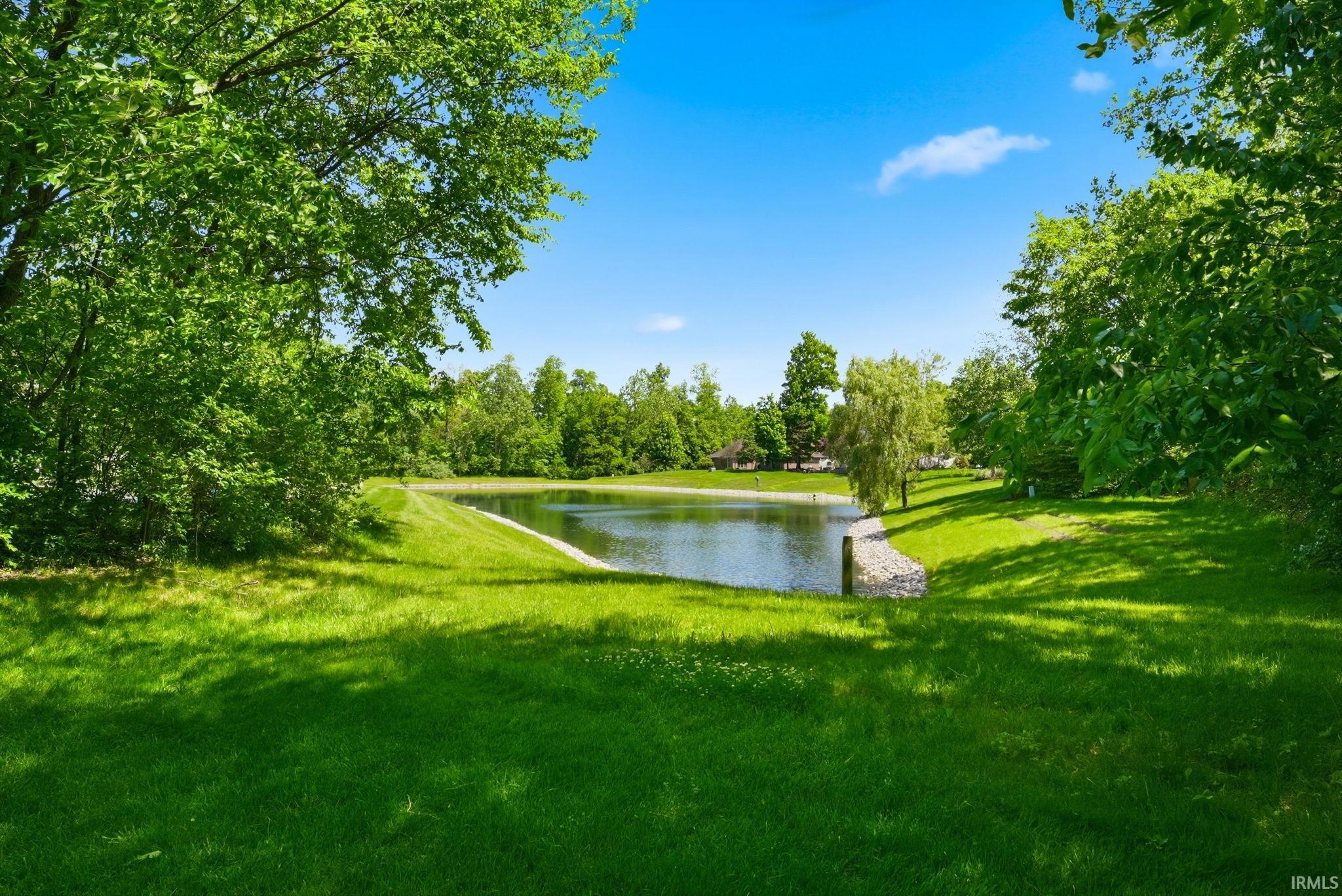 Expansive green lawn bordering a tranquil pond