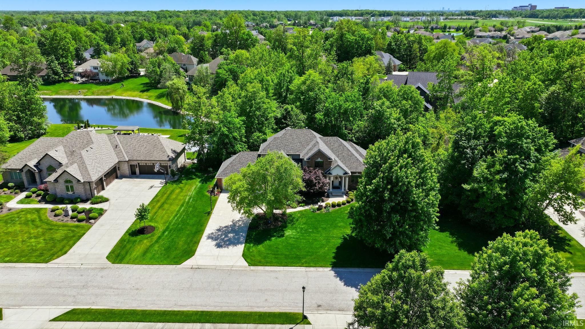 Expansive residential property featuring a large front yard with mature trees and a manicured lawn